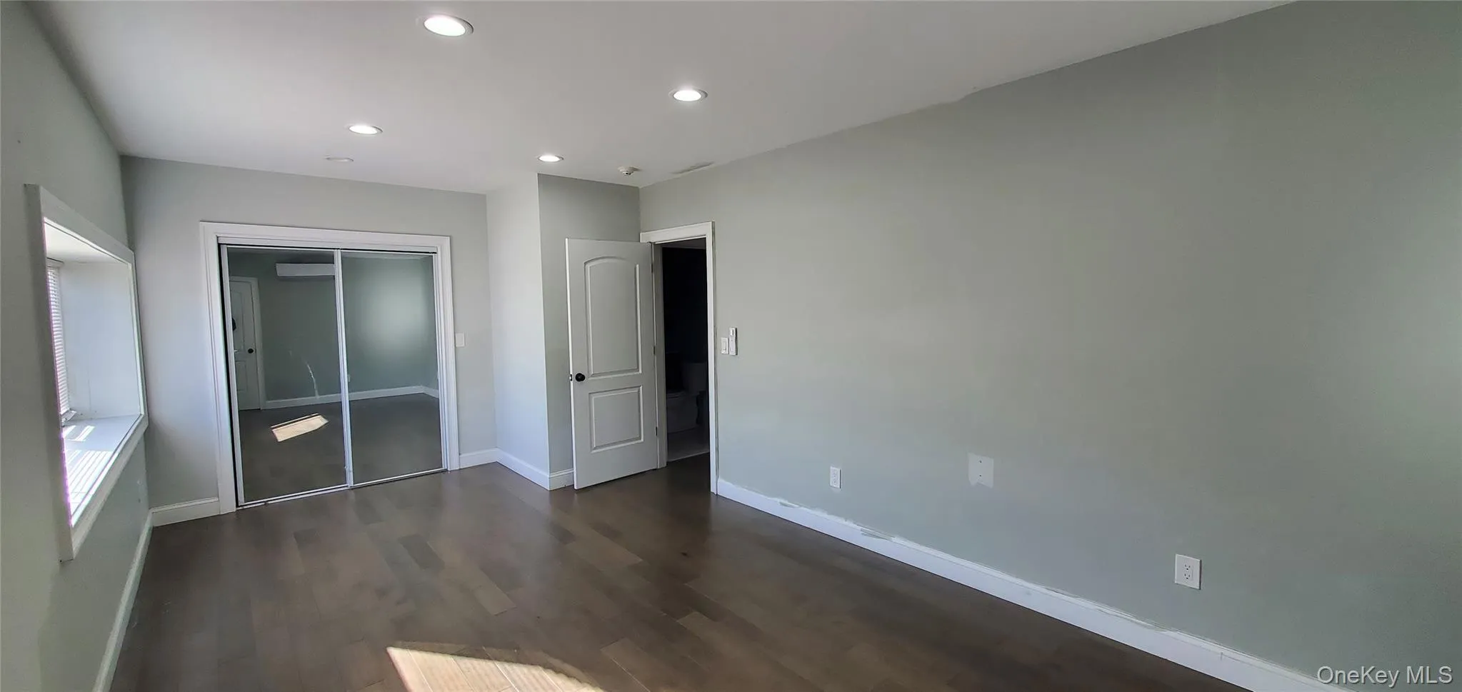 Unfurnished bedroom with a closet, recessed lighting, and dark wood-type flooring Unfurnished bedroom with a closet, recessed lighting, and dark wood-type flooring