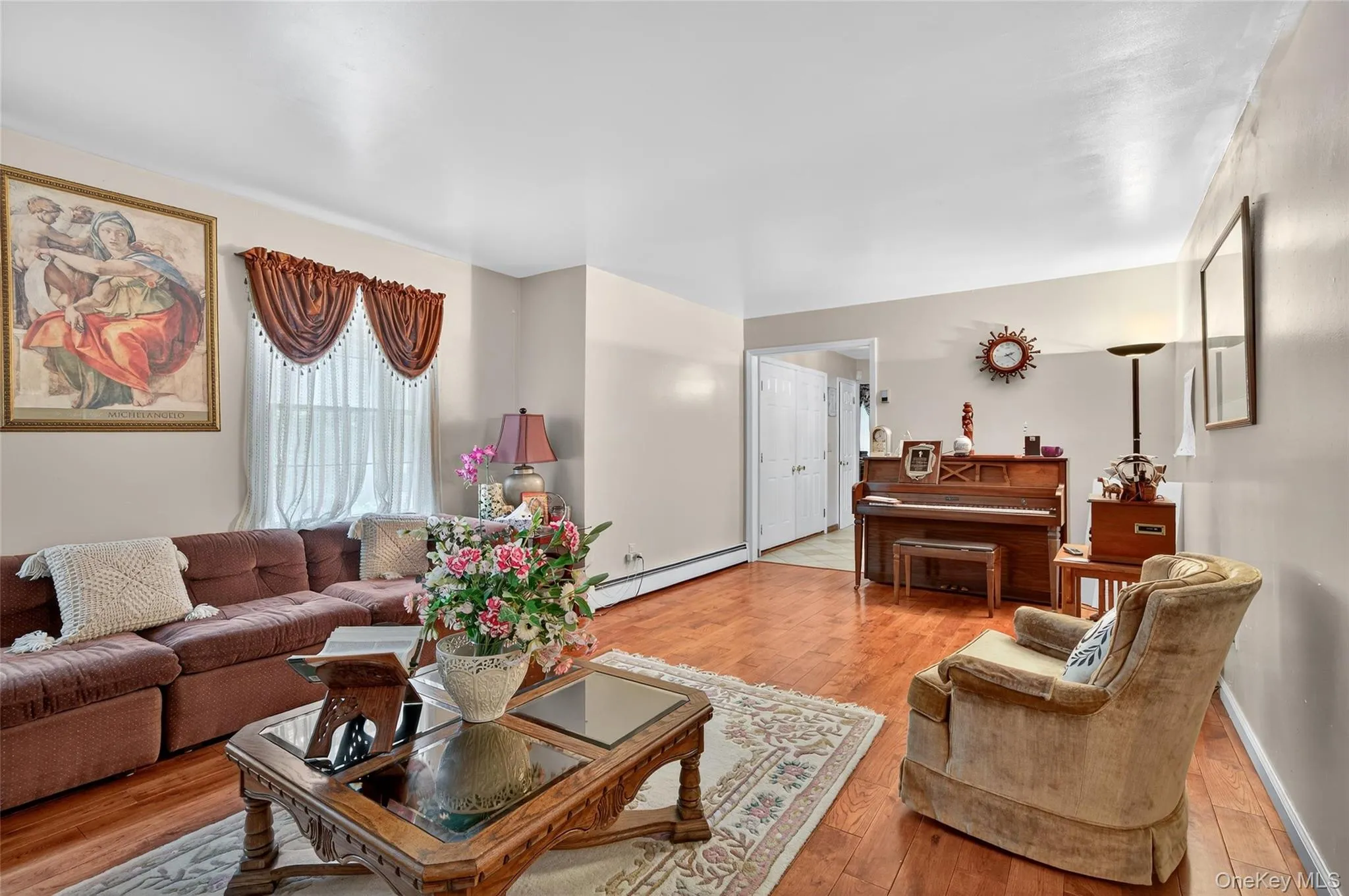 Living area featuring baseboard heating and light wood-style flooring Living area featuring baseboard heating and light wood-style flooring
