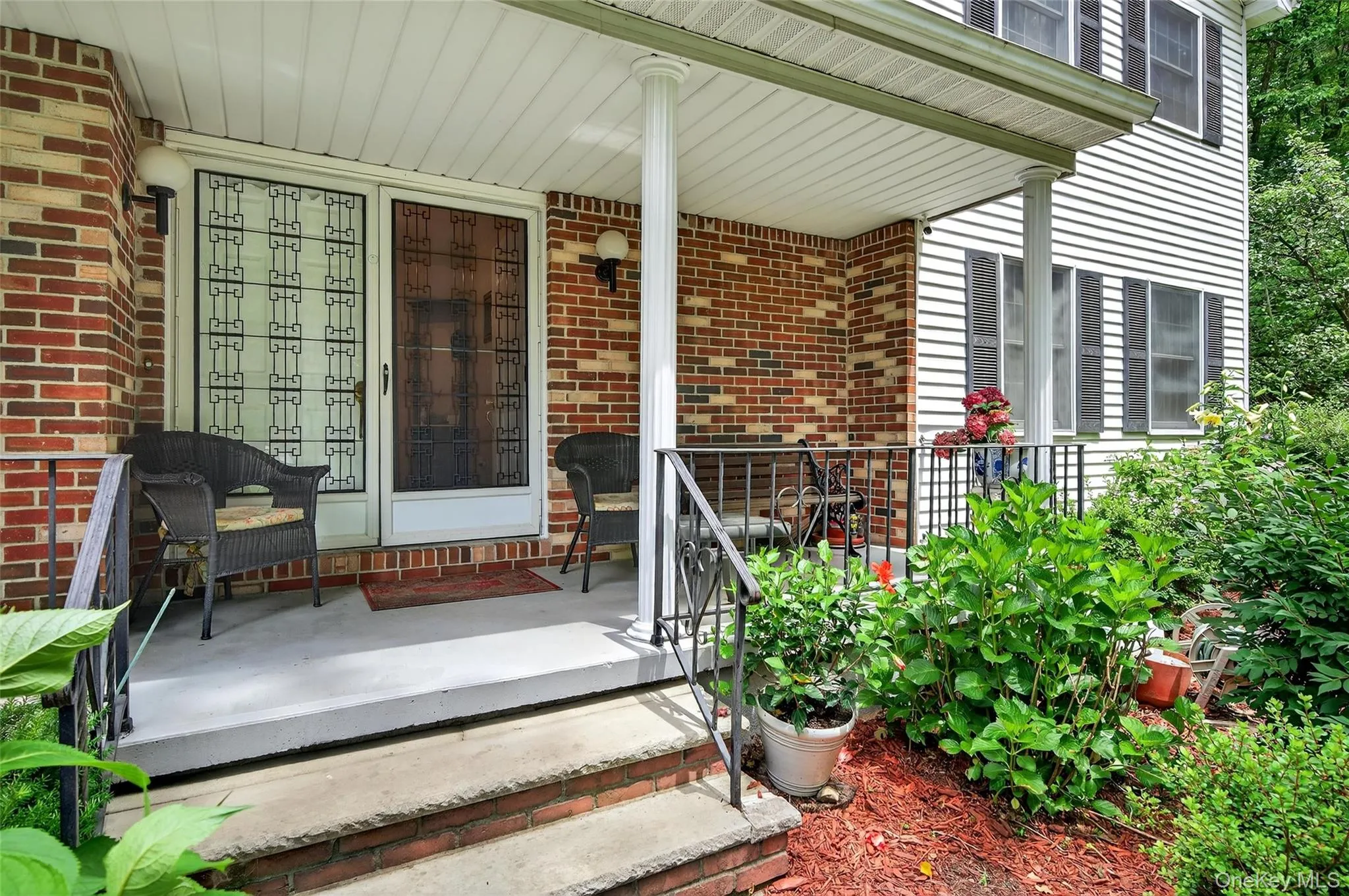 Doorway to property with covered porch and brick siding Doorway to property with covered porch and brick siding