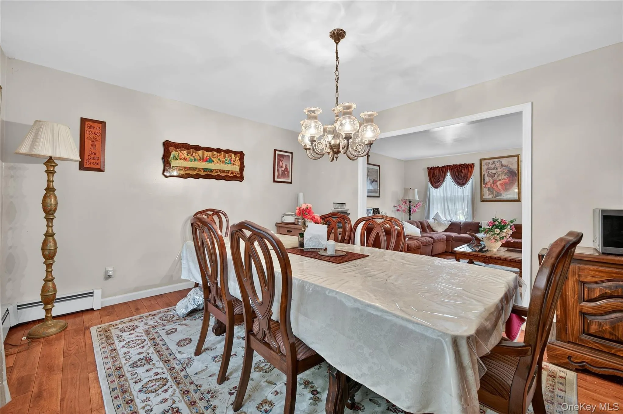 Dining area with light wood-style floors, a chandelier, and baseboard heating Dining area with light wood-style floors, a chandelier, and baseboard heating