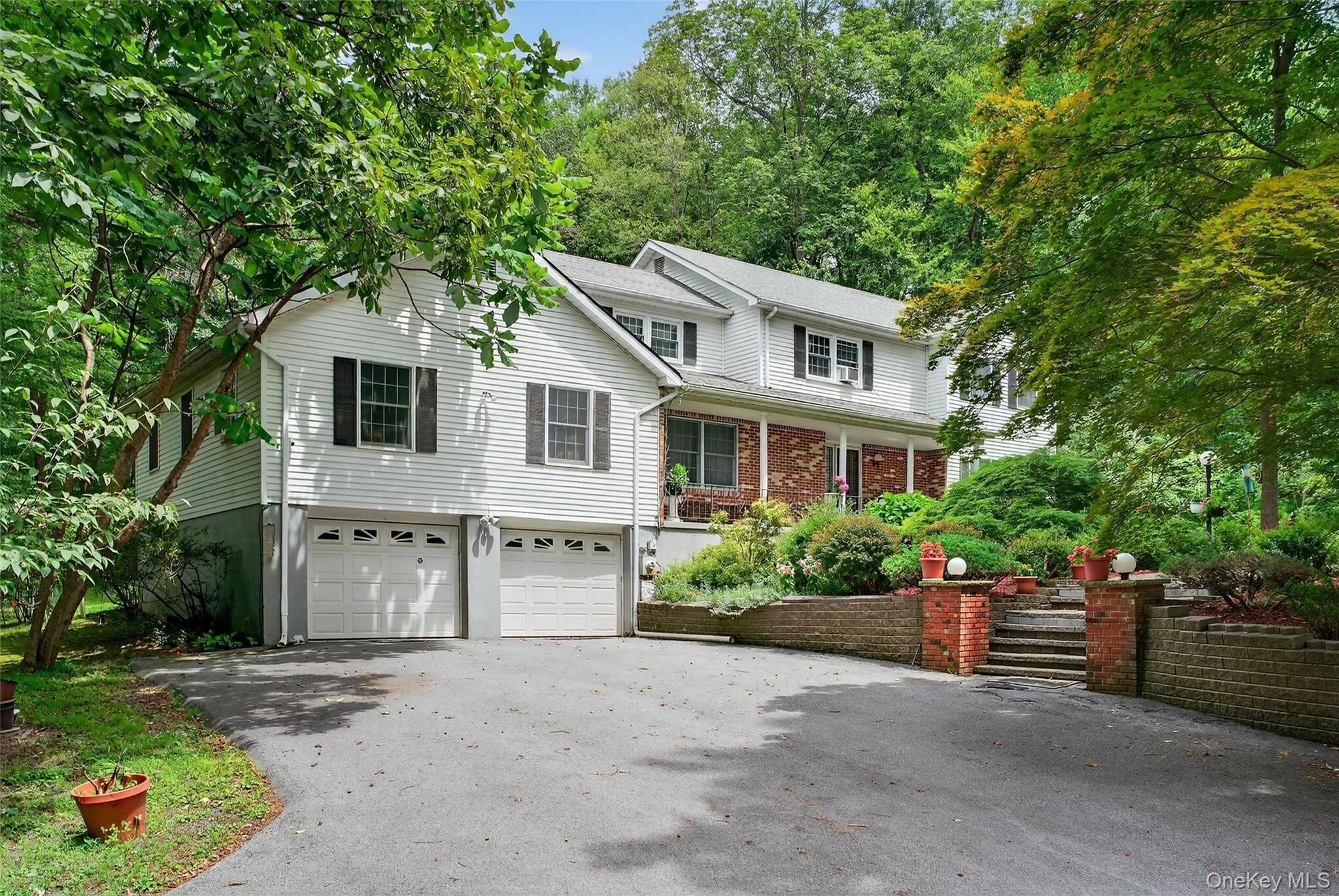 Traditional-style house with driveway, covered porch, and a garage Traditional-style house with driveway, covered porch, and a garage