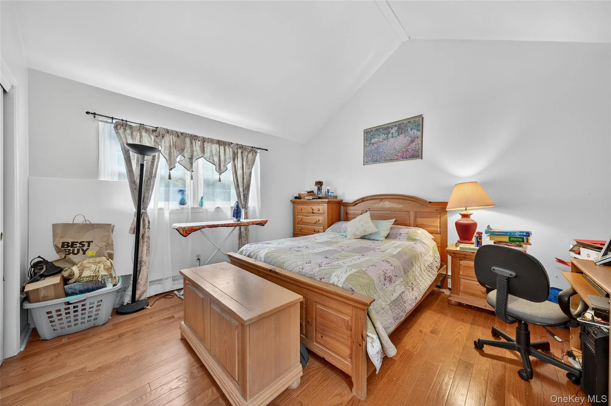 Bedroom with vaulted ceiling, light wood-type flooring, and baseboard heating Bedroom with vaulted ceiling, light wood-type flooring, and baseboard heating