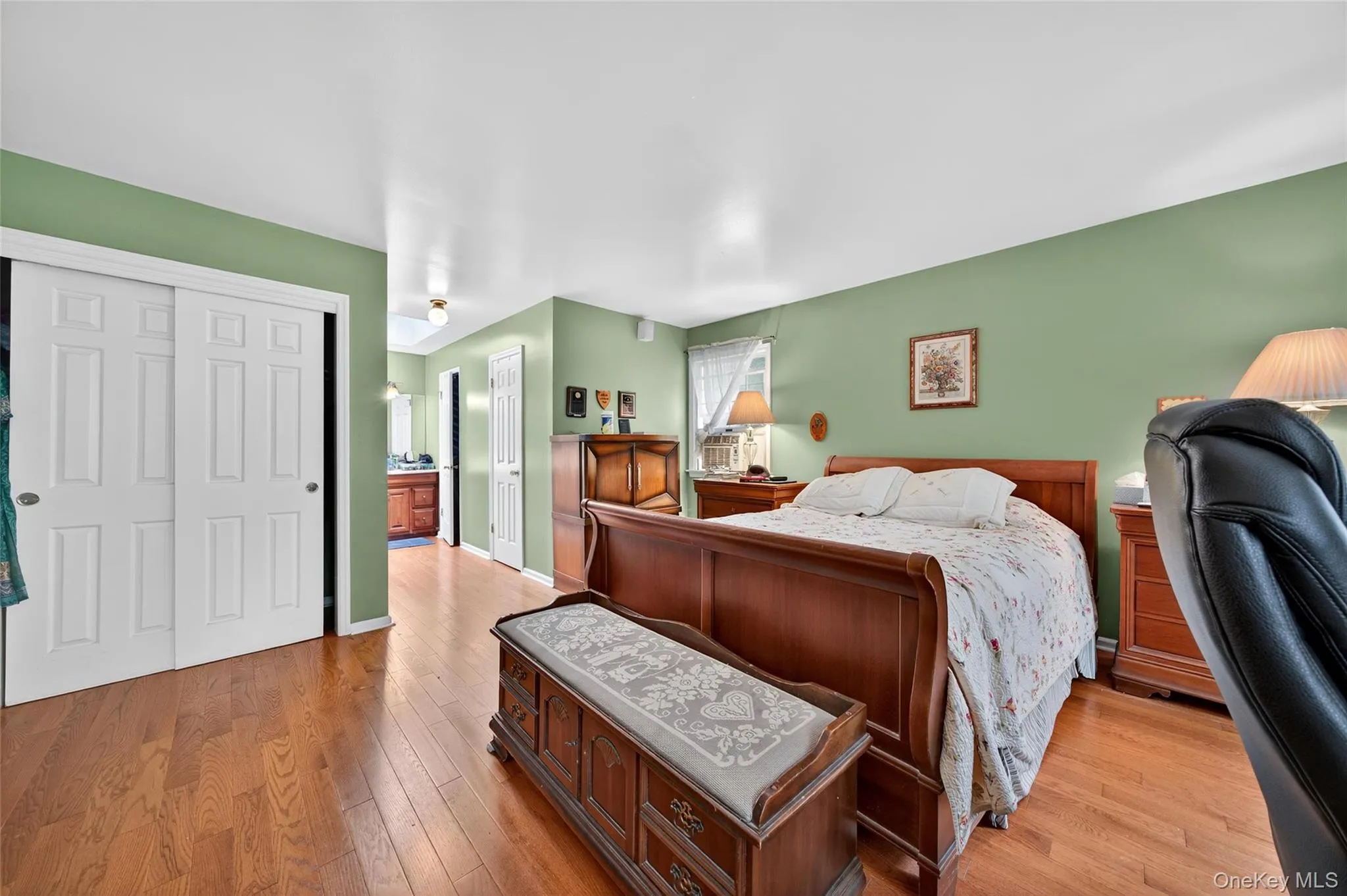 Bedroom with a closet, light wood-type flooring, and ensuite bath Bedroom with a closet, light wood-type flooring, and ensuite bath