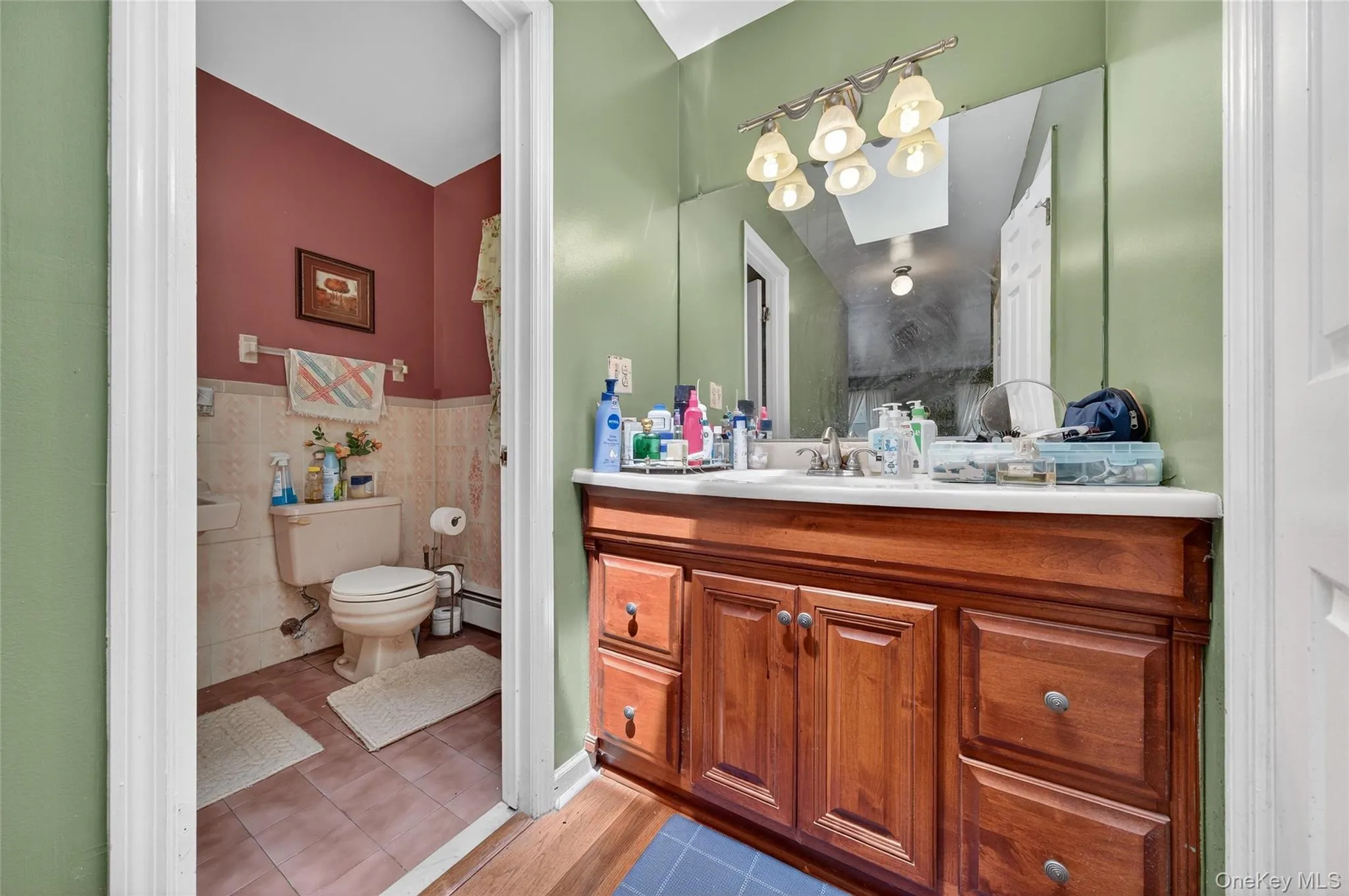 Bathroom with vanity, light tile patterned flooring, a wainscoted wall, and tile walls Bathroom with vanity, light tile patterned flooring, a wainscoted wall, and tile walls