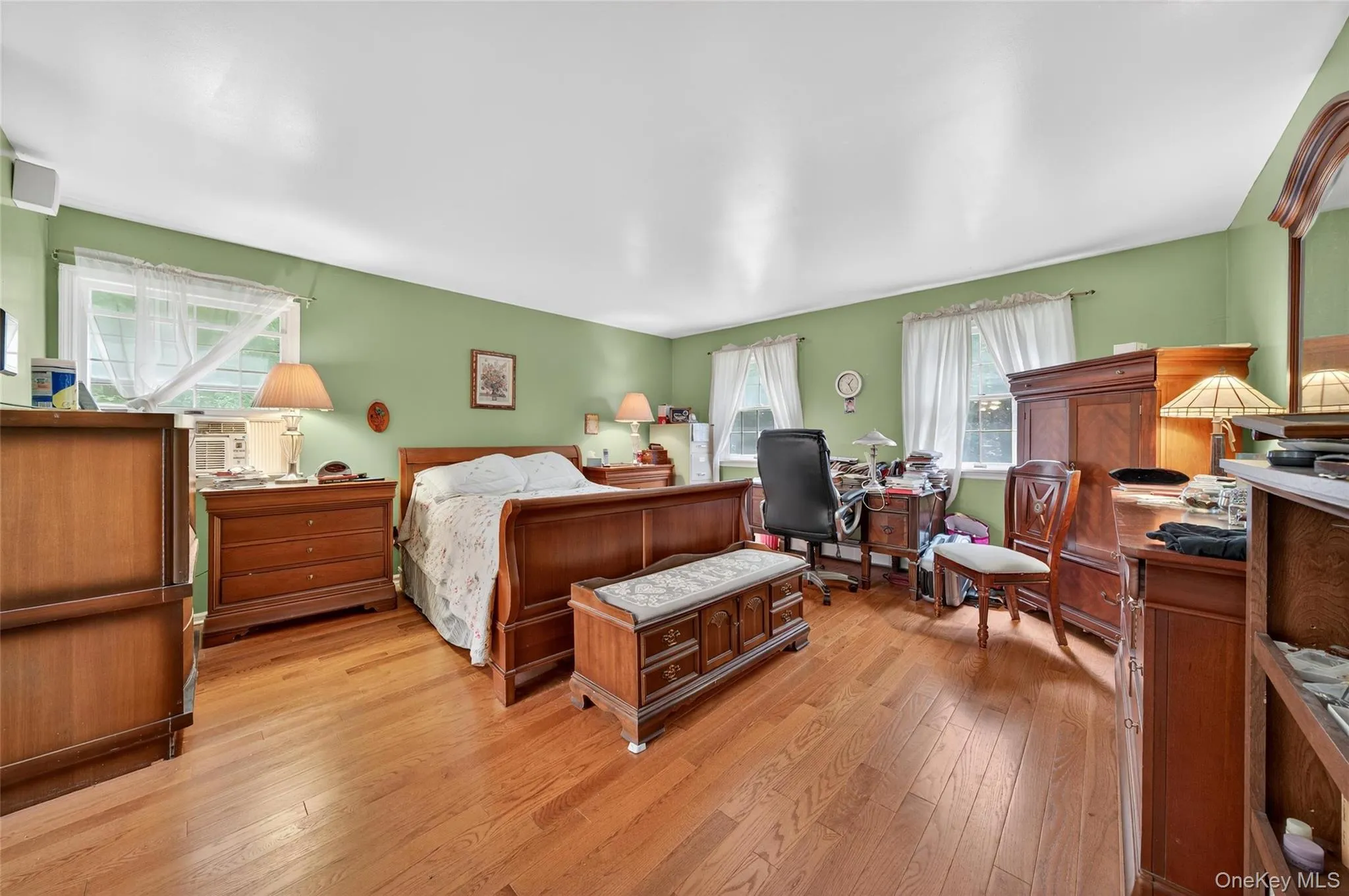 Bedroom with multiple windows and light wood-type flooring Bedroom with multiple windows and light wood-type flooring