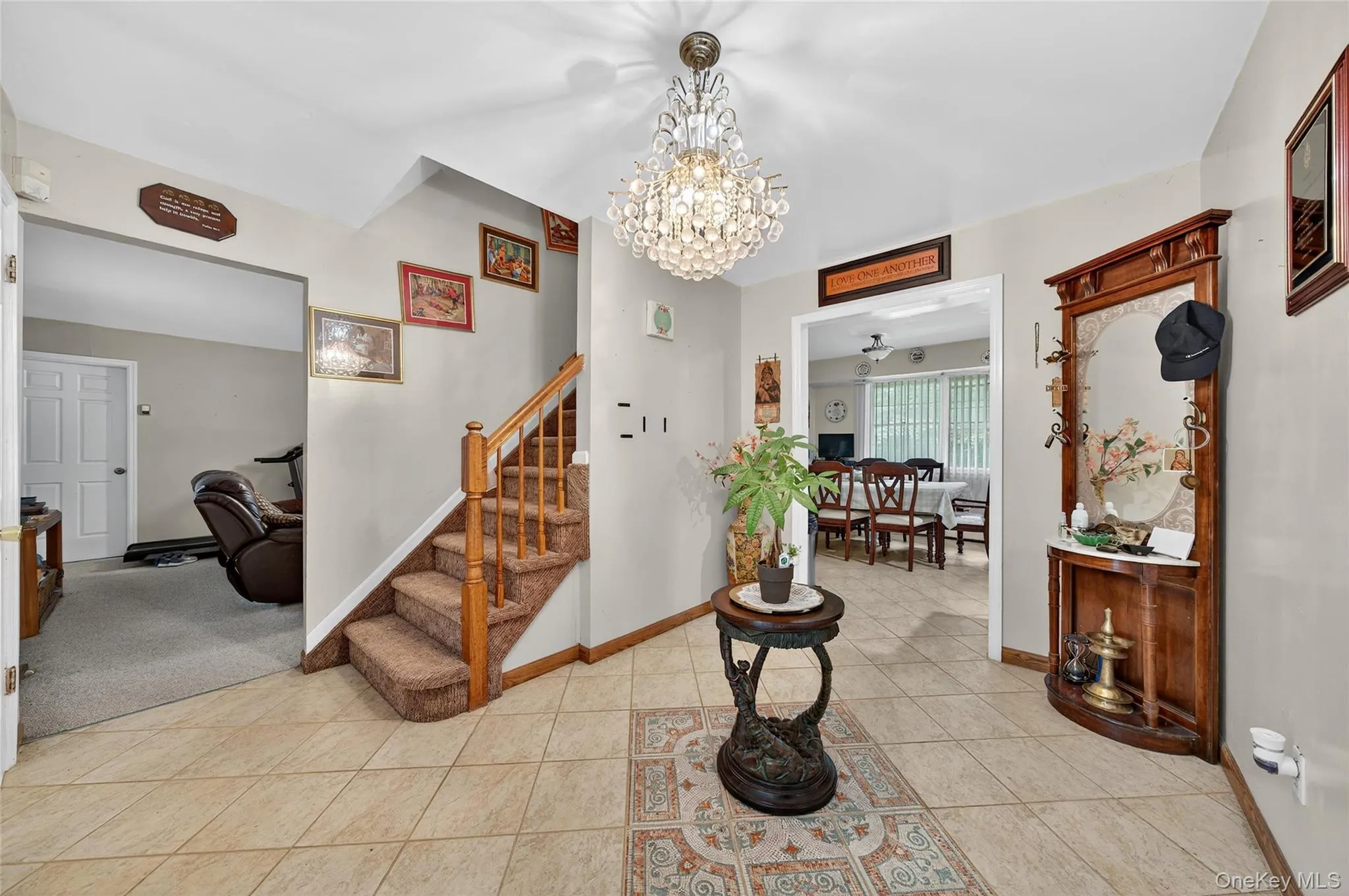 Foyer entrance featuring light tile patterned floors, a chandelier, and a ceiling fan Foyer entrance featuring light tile patterned floors, a chandelier, and a ceiling fan