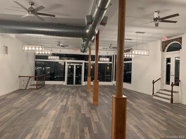 Room with ceiling fan, French doors, an upstairs landing, and stairs Room with ceiling fan, French doors, an upstairs landing, and stairs