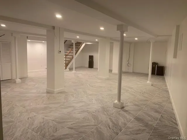 Finished below grade area with stairway and baseboards Finished below grade area with stairway and baseboards