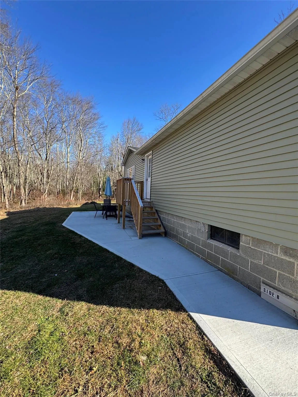 View of side of property with a patio and a yard View of side of property with a patio and a yard