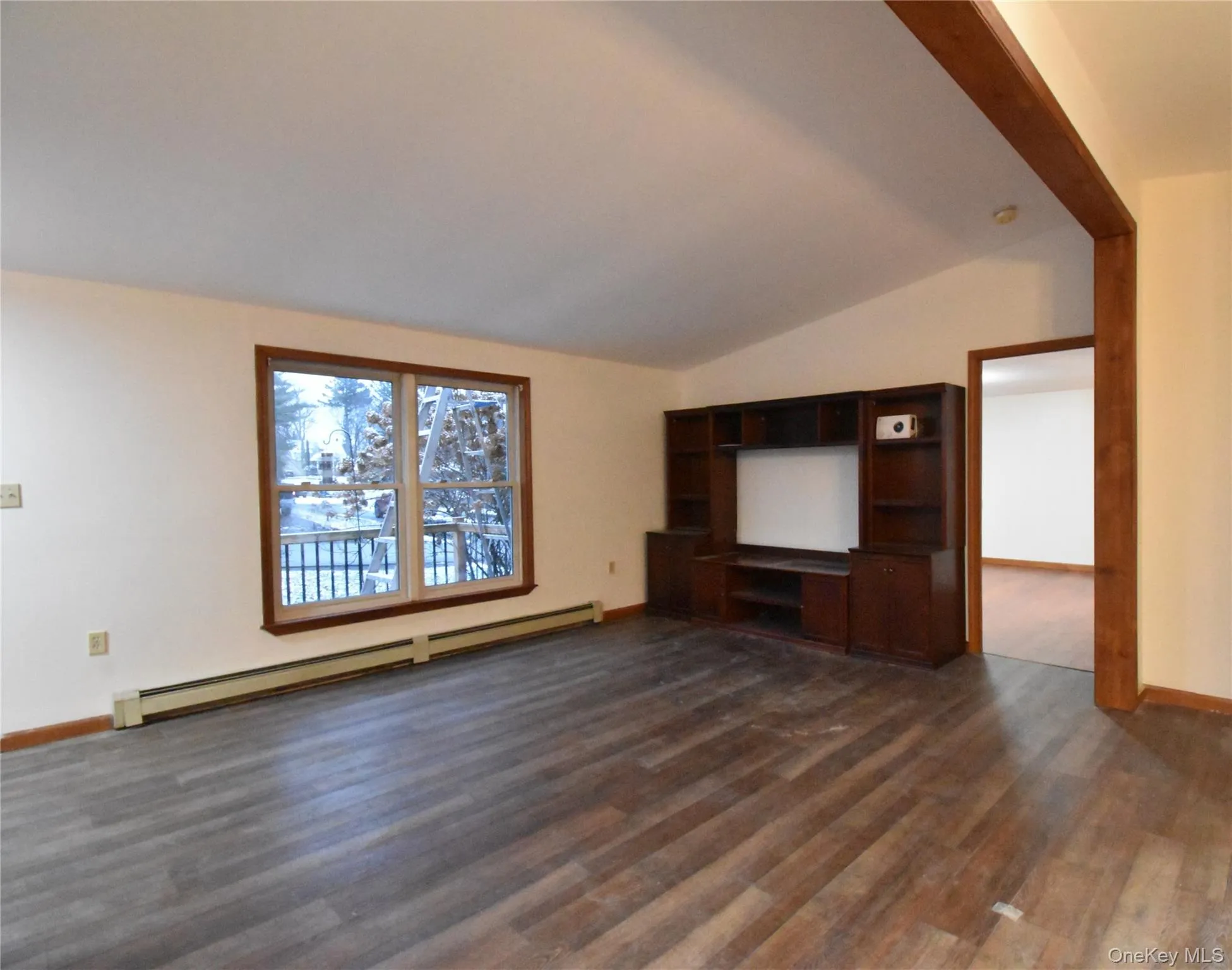 Unfurnished living room featuring a baseboard radiator, dark wood-style flooring, and lofted ceiling Unfurnished living room featuring a baseboard radiator, dark wood-style flooring, and lofted ceiling