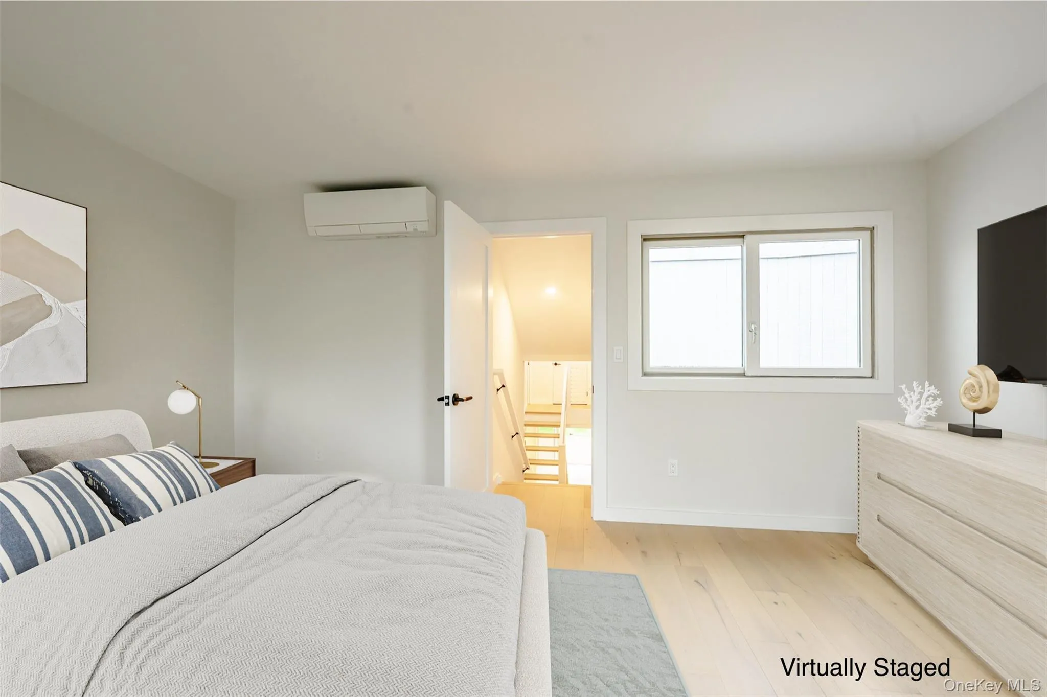 Bedroom with wood finished floors and a wall mounted air conditioner Bedroom with wood finished floors and a wall mounted air conditioner