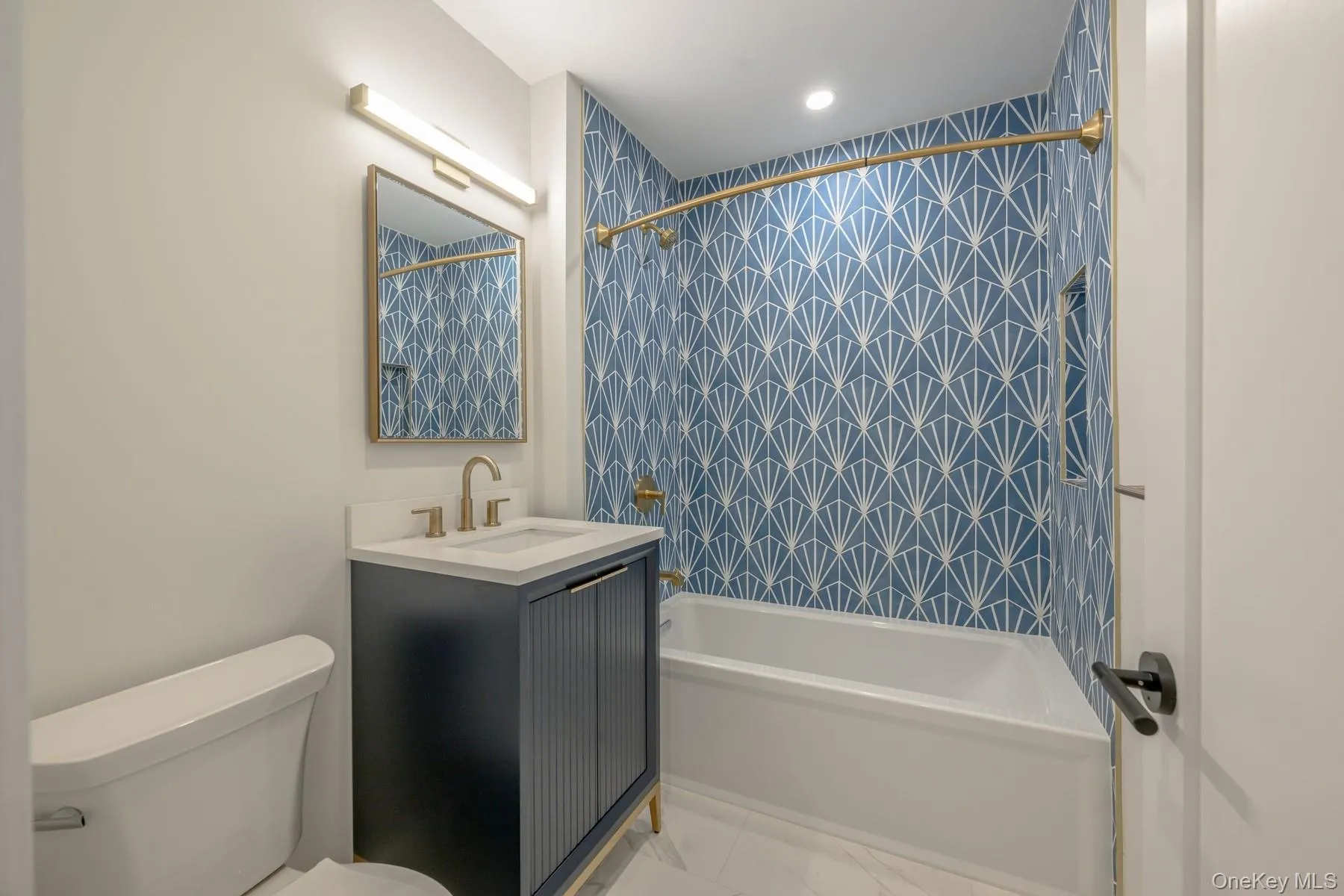Full bathroom with vanity, shower / tub combo with curtain, light marble finish flooring, and recessed lighting Full bathroom with vanity, shower / tub combo with curtain, light marble finish flooring, and recessed lighting