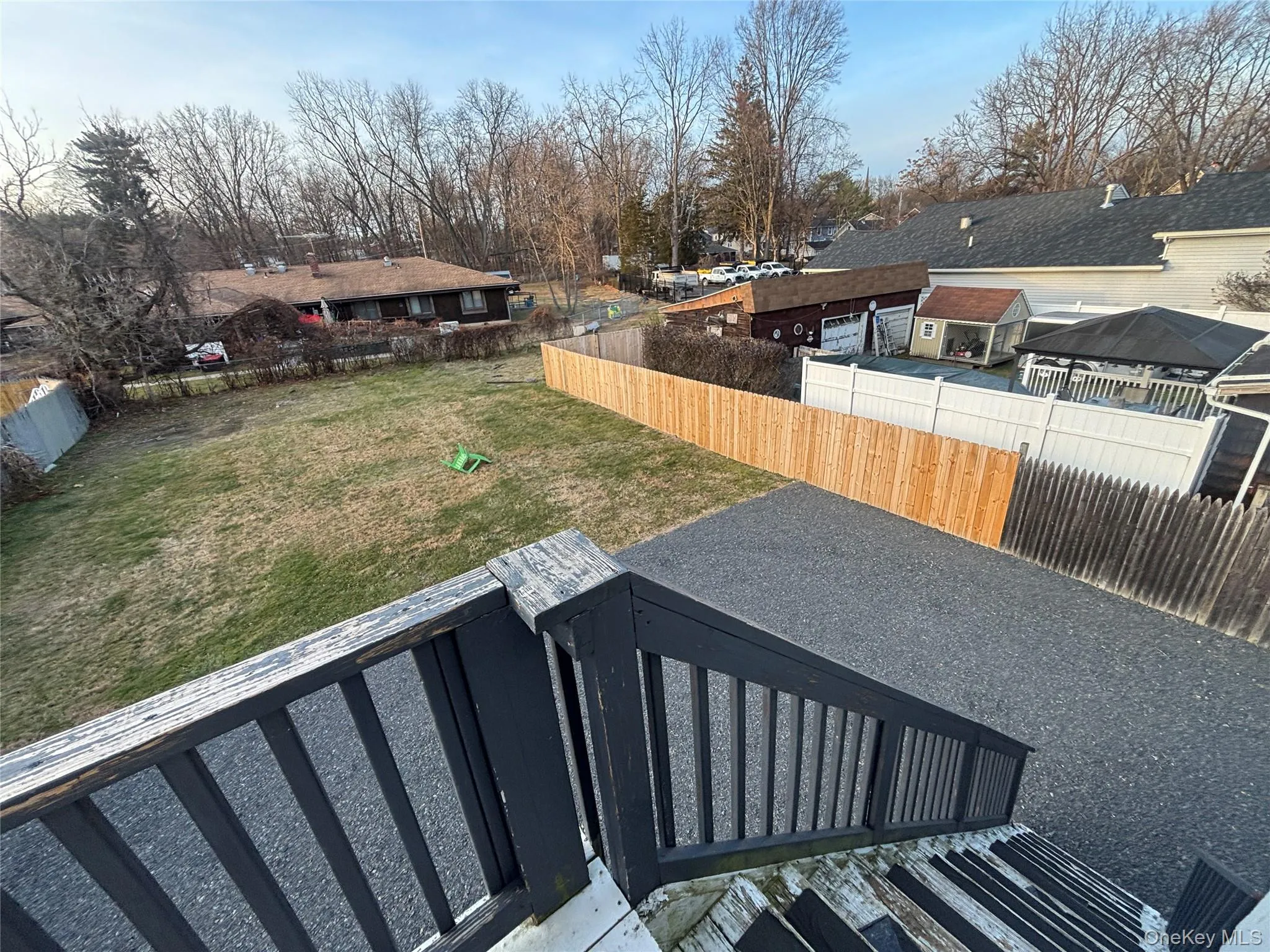 Fenced backyard with a residential view Fenced backyard with a residential view