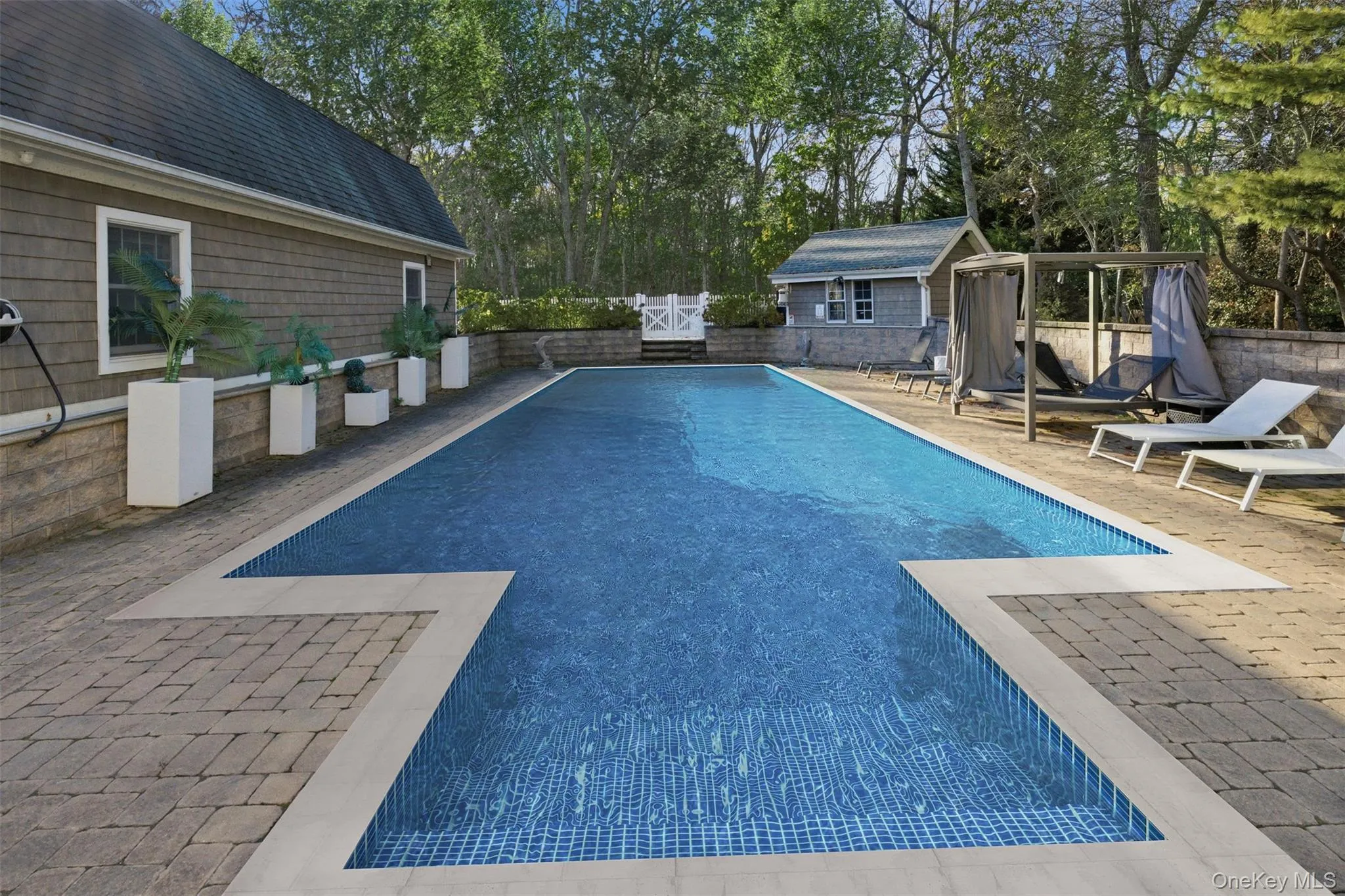 View of pool with a patio area, a fenced backyard, an outbuilding, and view of wooded area View of pool with a patio area, a fenced backyard, an outbuilding, and view of wooded area