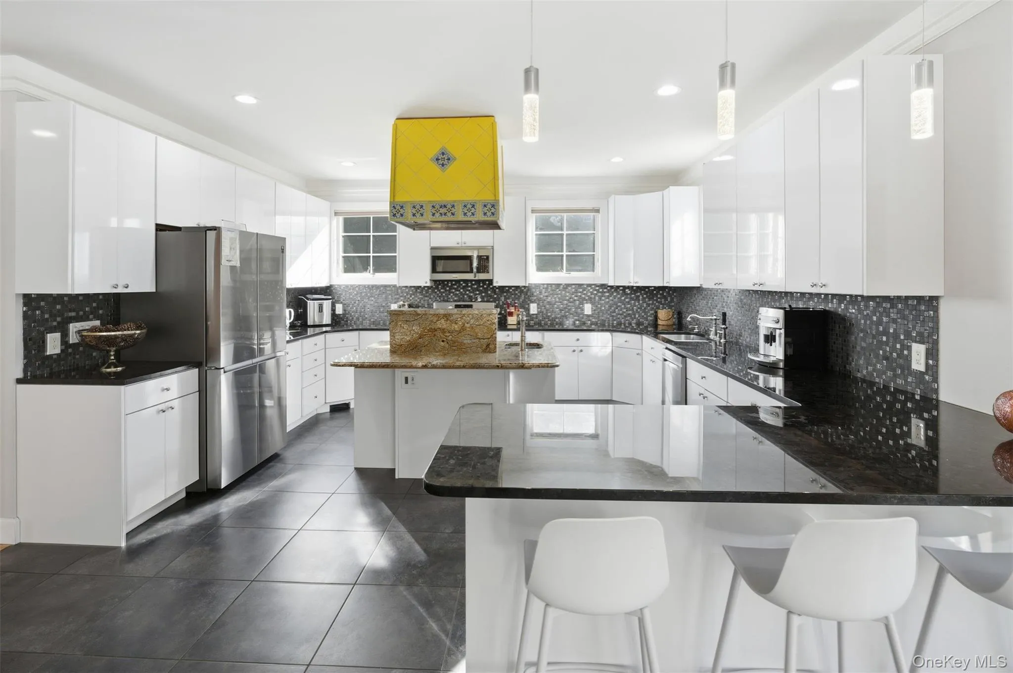 Kitchen with decorative backsplash, white cabinets, appliances with stainless steel finishes, and recessed lighting Kitchen with decorative backsplash, white cabinets, appliances with stainless steel finishes, and recessed lighting