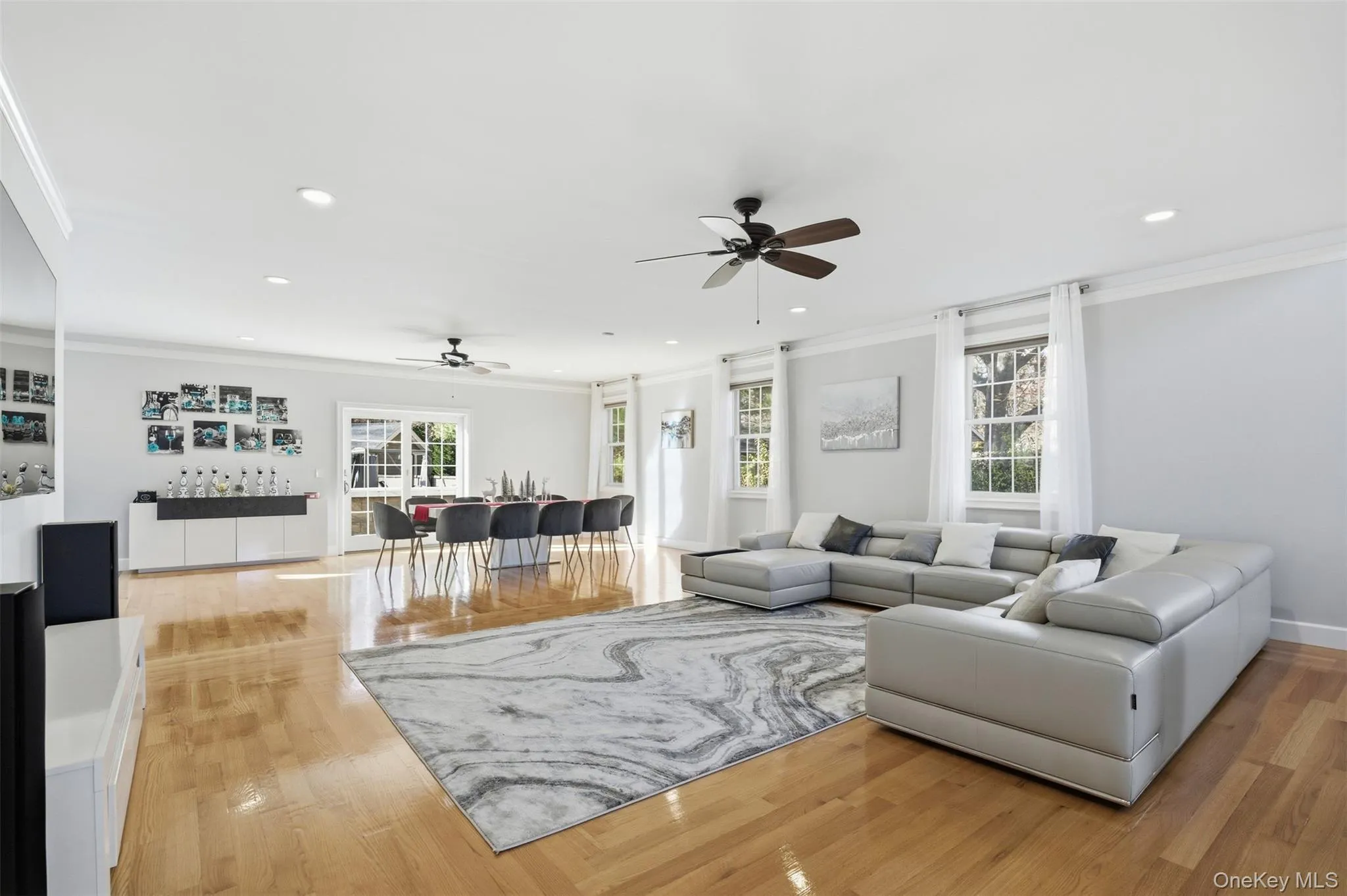 Living room with ornamental molding, ceiling fan, light wood-type flooring, and recessed lighting Living room with ornamental molding, ceiling fan, light wood-type flooring, and recessed lighting