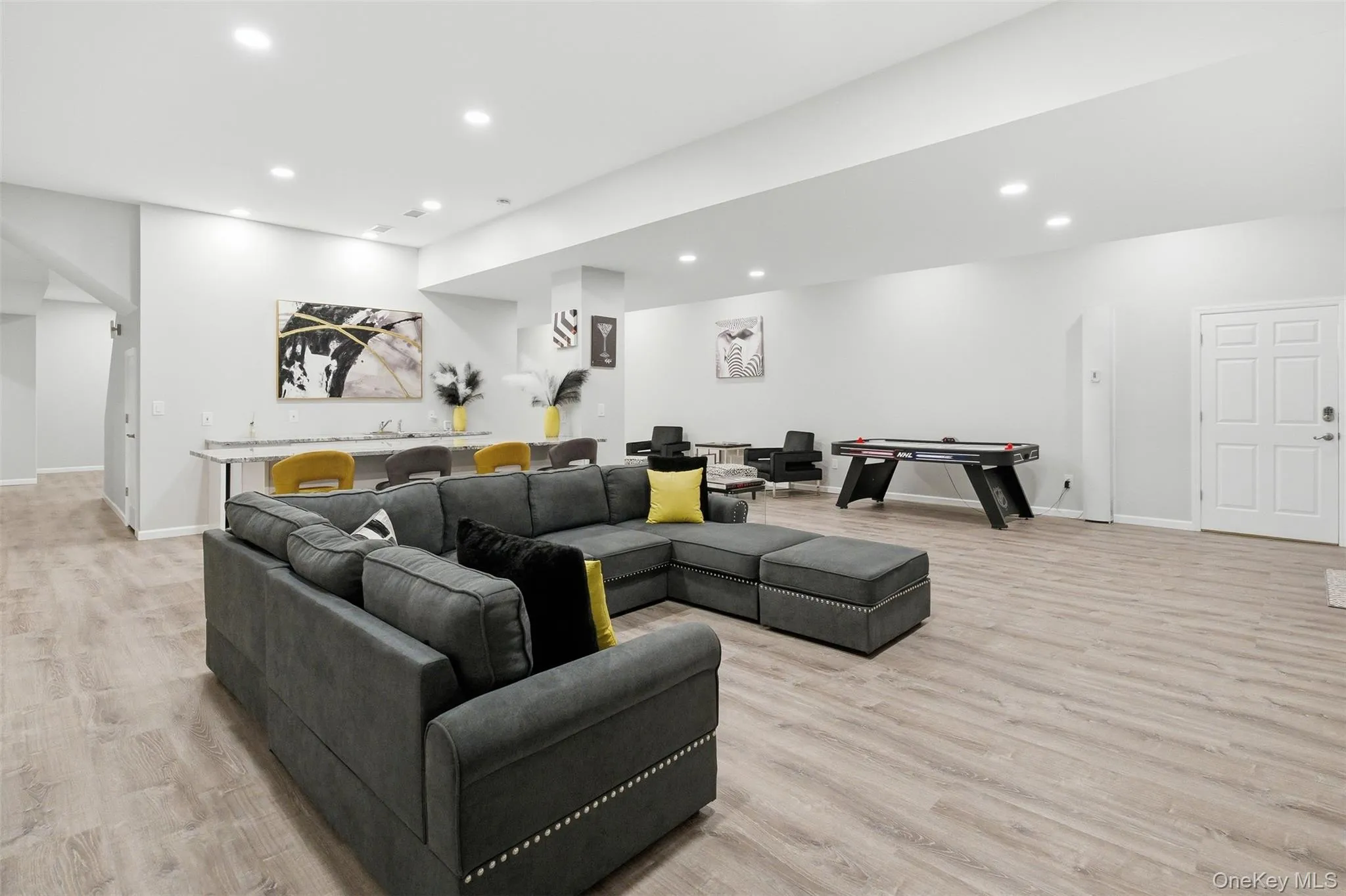 Living area featuring recessed lighting, light wood finished floors, and arched walkways Living area featuring recessed lighting, light wood finished floors, and arched walkways