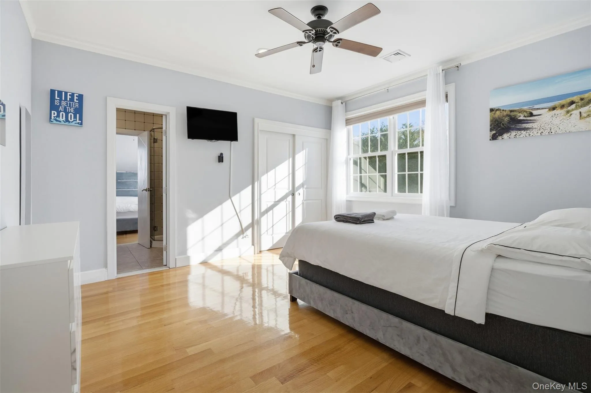 Bedroom with ornamental molding, light wood finished floors, a closet, and ceiling fan Bedroom with ornamental molding, light wood finished floors, a closet, and ceiling fan