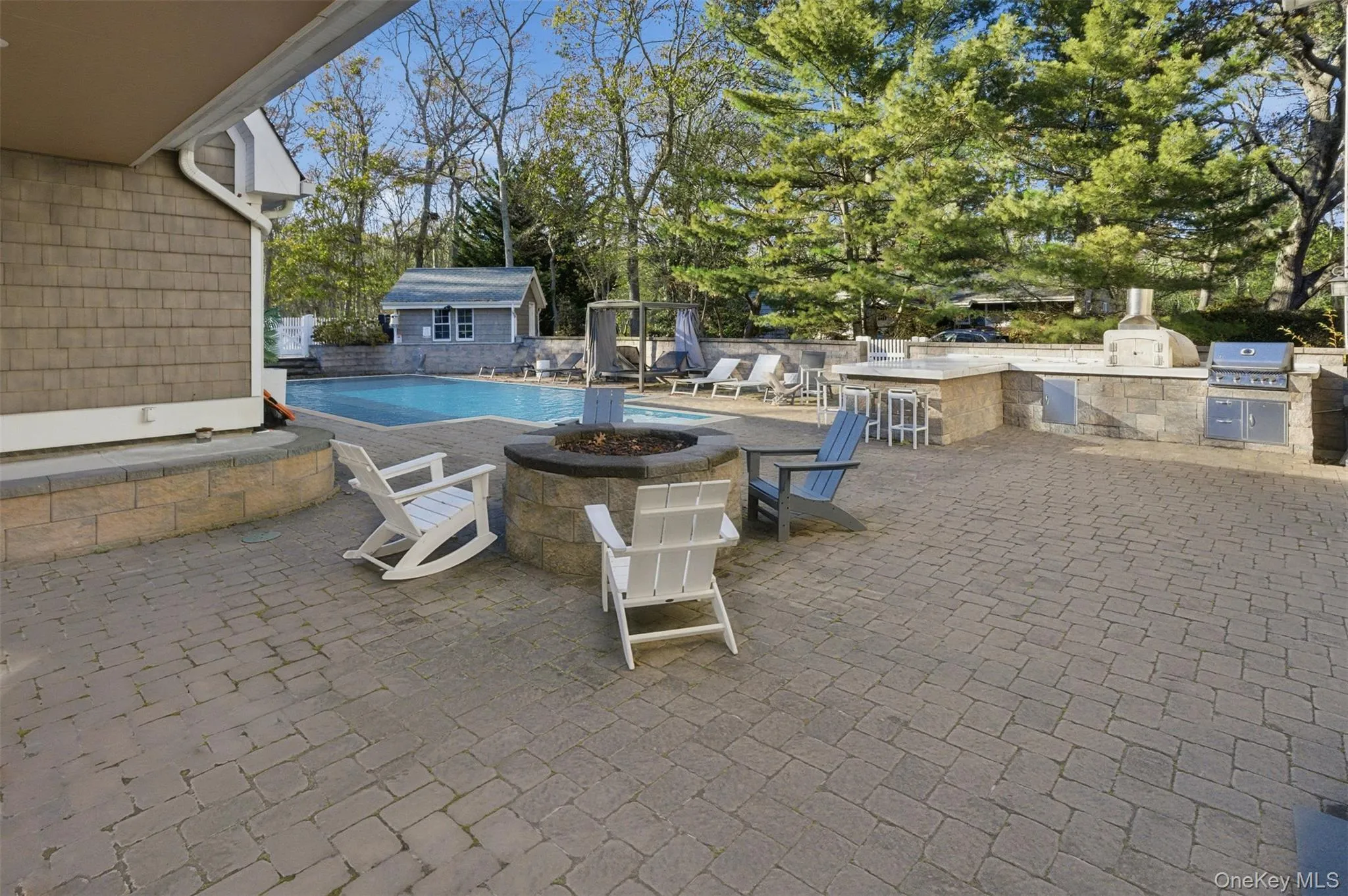 View of swimming pool with exterior kitchen, a patio area, a fire pit, and an outdoor structure View of swimming pool with exterior kitchen, a patio area, a fire pit, and an outdoor structure