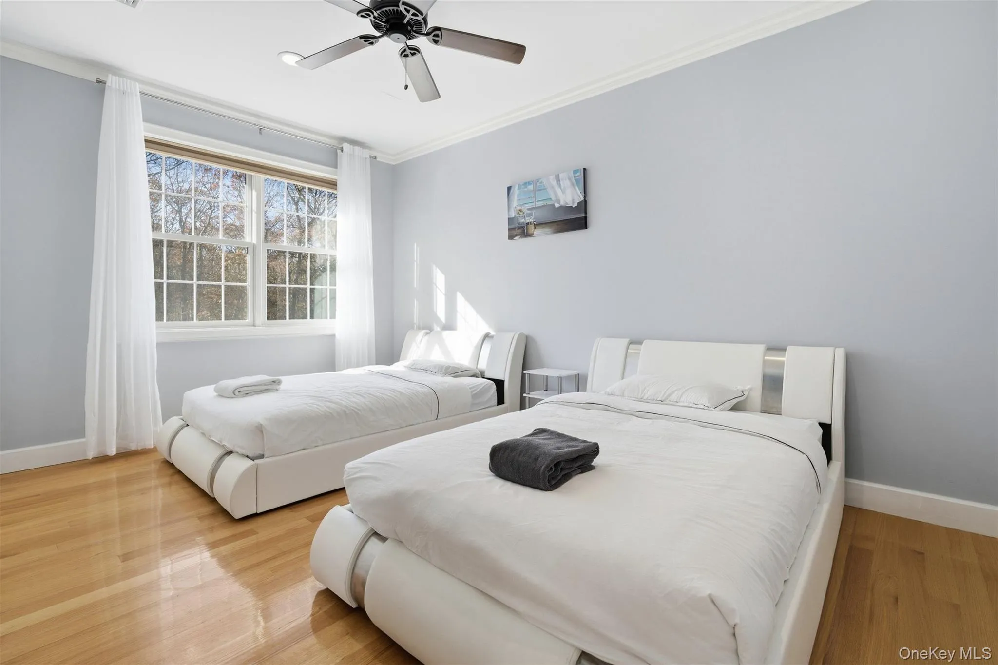 Bedroom featuring crown molding, ceiling fan, and wood finished floors Bedroom featuring crown molding, ceiling fan, and wood finished floors