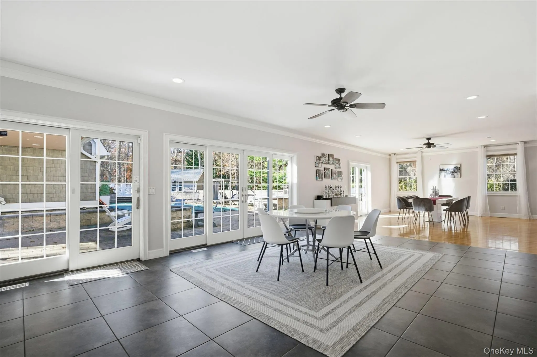 Dining space featuring crown molding, healthy amount of natural light, recessed lighting, tile patterned floors, and a ceiling fan Dining space featuring crown molding, healthy amount of natural light, recessed lighting, tile patterned floors, and a ceiling fan