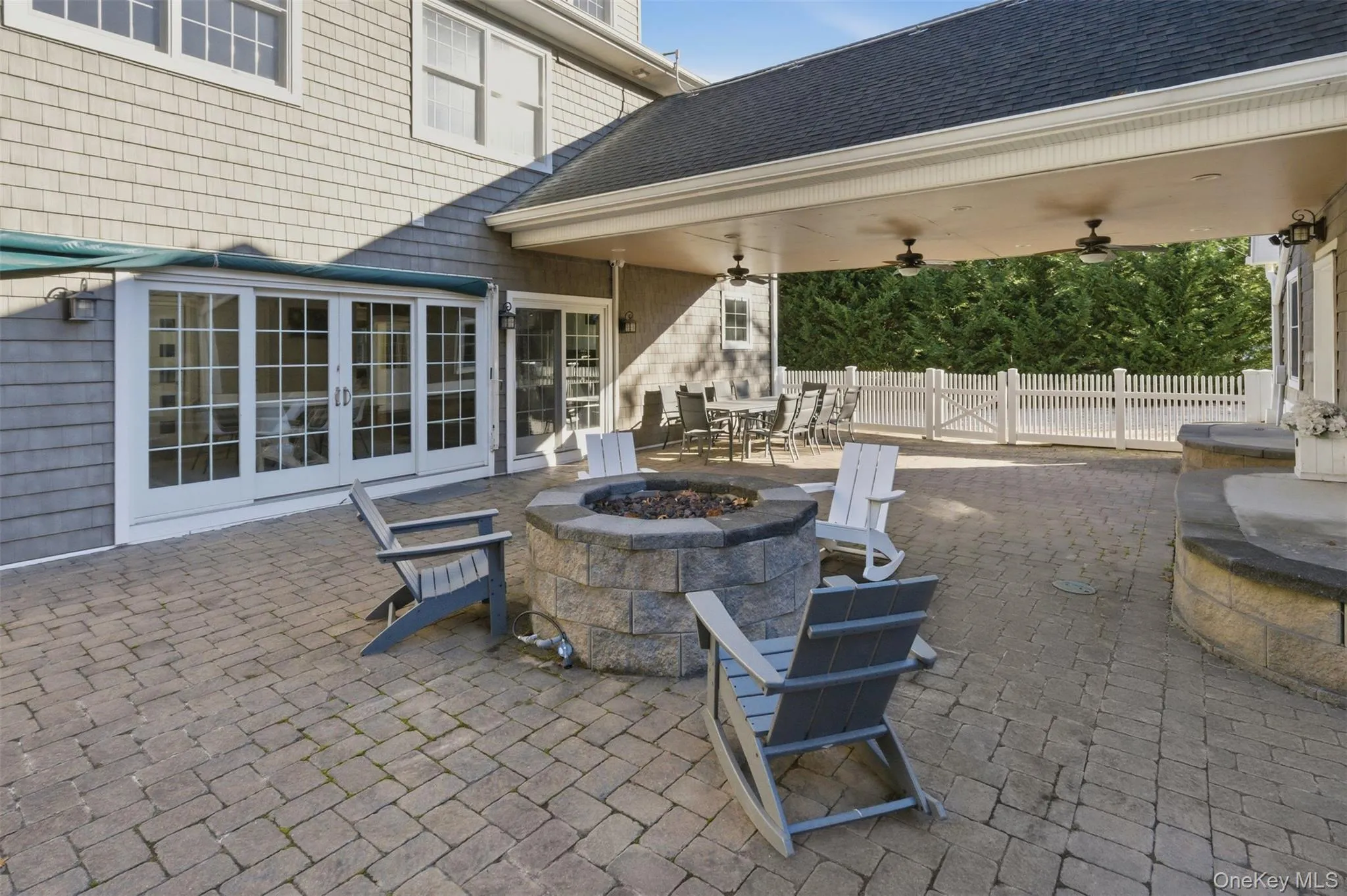 View of patio / terrace featuring a fire pit, outdoor dining area, french doors, and ceiling fan View of patio / terrace featuring a fire pit, outdoor dining area, french doors, and ceiling fan