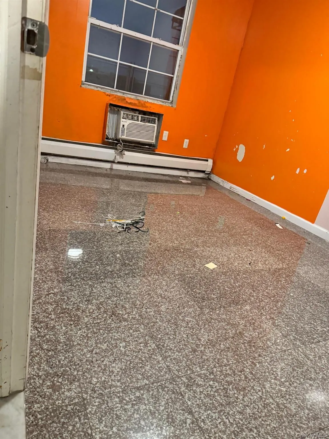 Detailed view of a baseboard heating unit, carpet, and a wall mounted AC Detailed view of a baseboard heating unit, carpet, and a wall mounted AC