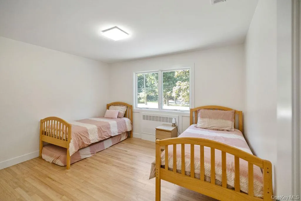 Bedroom featuring light wood-type flooring and radiator Bedroom featuring light wood-type flooring and radiator