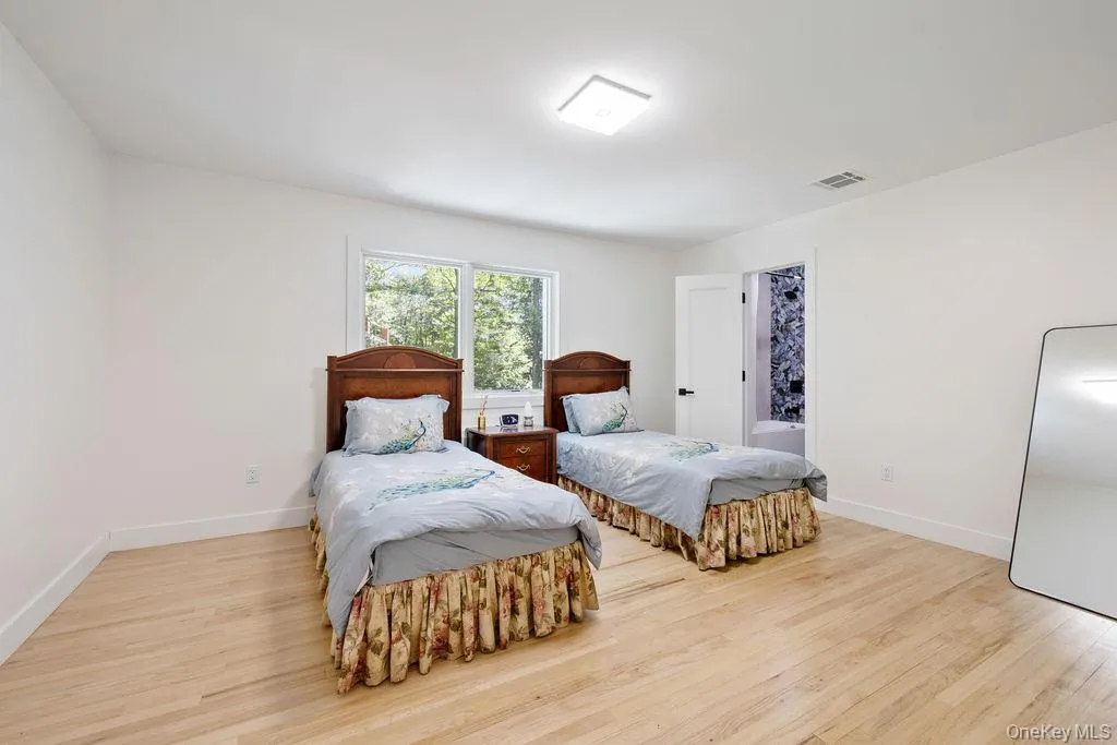 Bedroom with light wood-type flooring and baseboards Bedroom with light wood-type flooring and baseboards