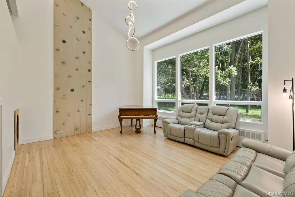 Living area featuring light wood-style flooring and high vaulted ceiling Living area featuring light wood-style flooring and high vaulted ceiling