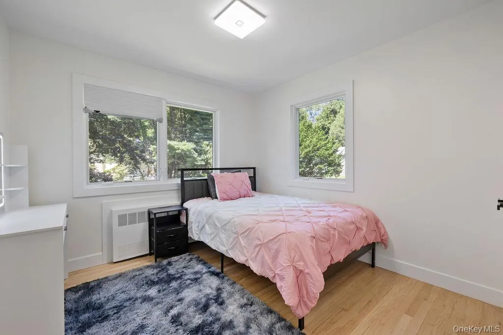 Bedroom featuring radiator and light wood-style floors Bedroom featuring radiator and light wood-style floors