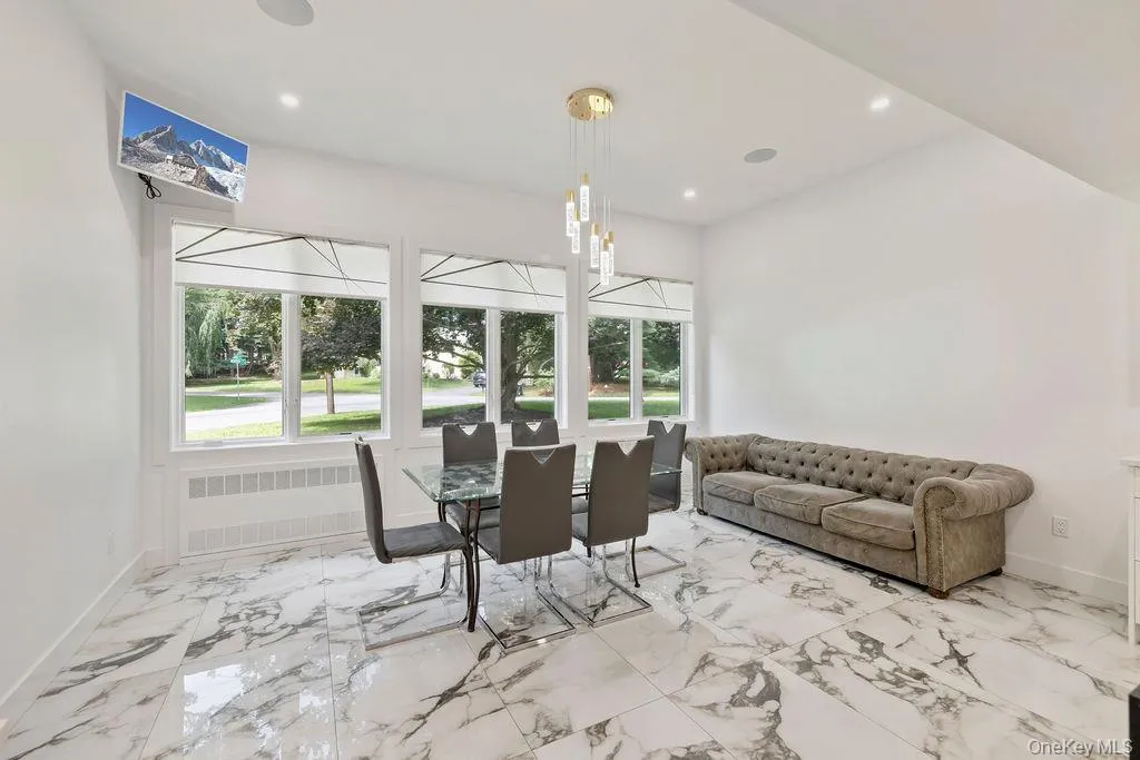 Dining room with radiator heating unit, light marble finish flooring, and recessed lighting Dining room with radiator heating unit, light marble finish flooring, and recessed lighting