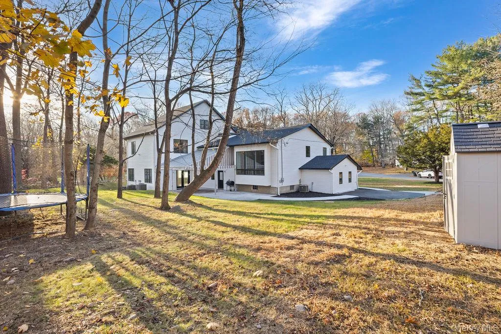 Rear view of house with a patio and a lawn Rear view of house with a patio and a lawn