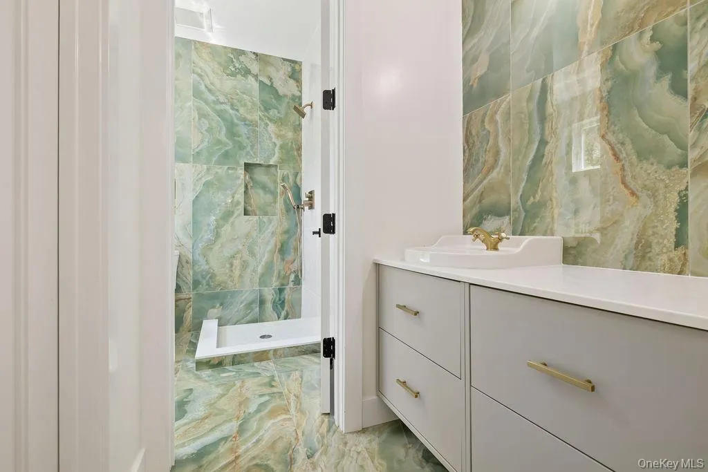 Full bathroom with vanity and a marble finish shower Full bathroom with vanity and a marble finish shower
