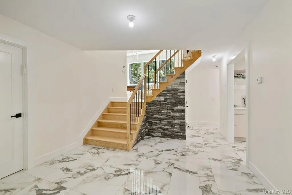 Foyer featuring stairway and light marble finish floors Foyer featuring stairway and light marble finish floors