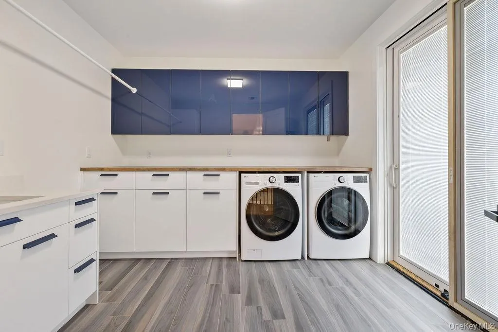 Laundry room featuring washer and clothes dryer and light wood-type flooring Laundry room featuring washer and clothes dryer and light wood-type flooring