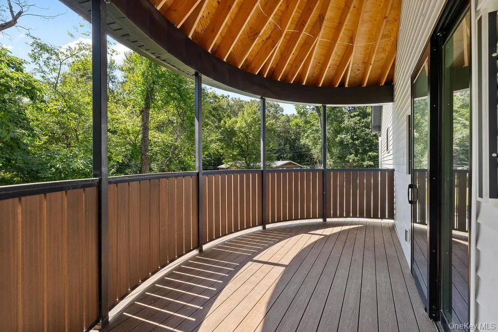 Unfurnished sunroom with a deck and vaulted ceiling Unfurnished sunroom with a deck and vaulted ceiling