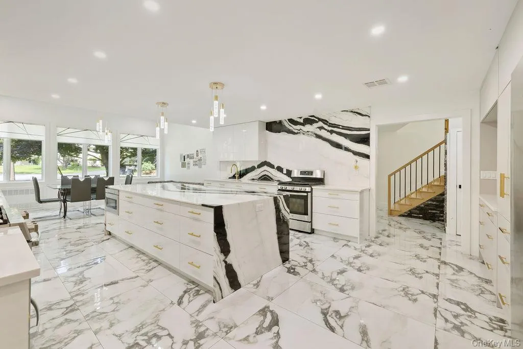 Kitchen with white cabinets, light stone countertops, stainless steel gas range oven, pendant lighting, and recessed lighting Kitchen with white cabinets, light stone countertops, stainless steel gas range oven, pendant lighting, and recessed lighting