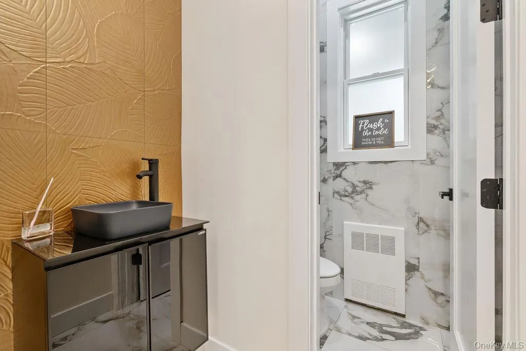 Bathroom featuring marble tiled flooring and vanity Bathroom featuring marble tiled flooring and vanity