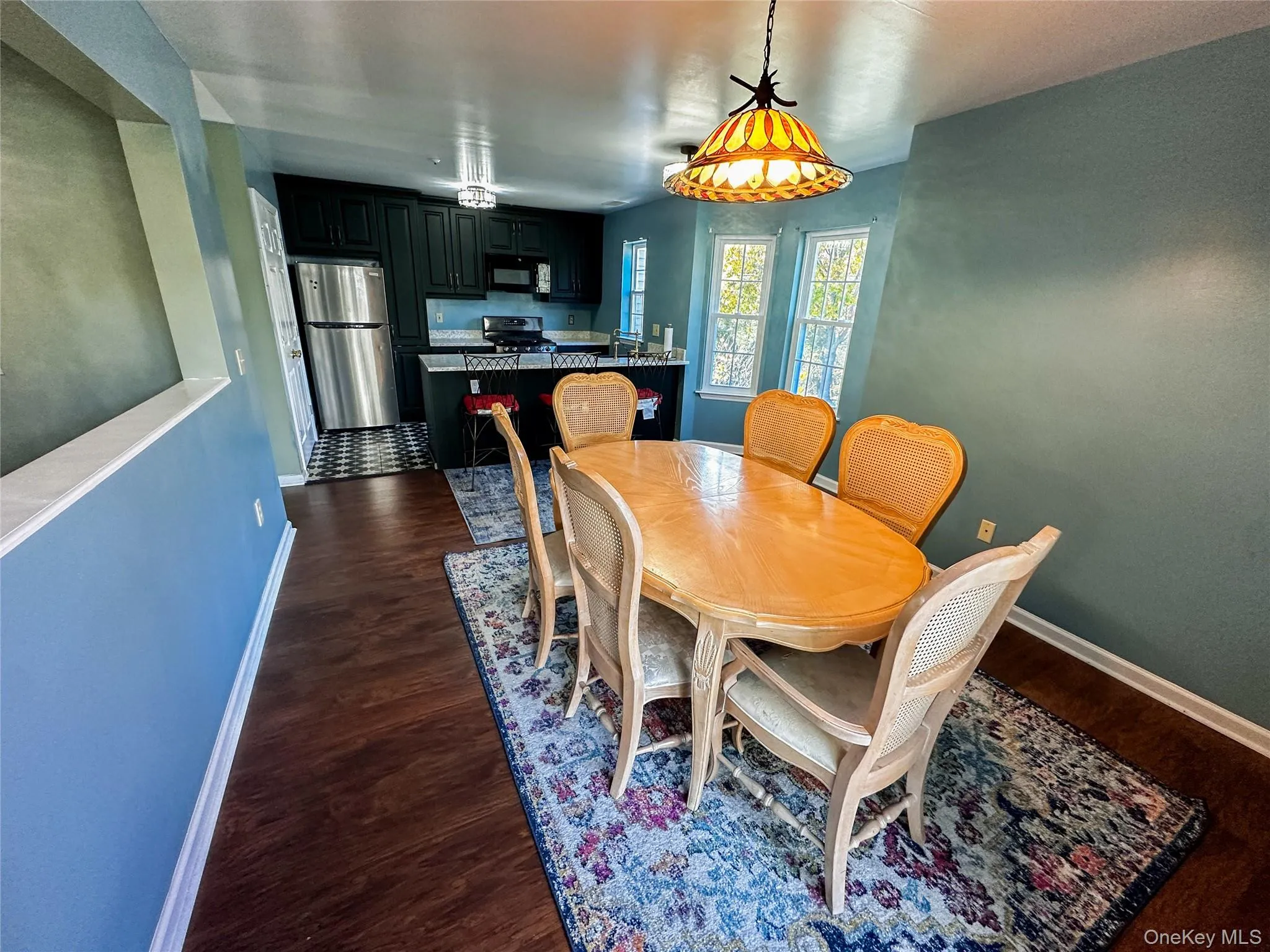 Dining space featuring baseboards and dark wood finished floors Dining space featuring baseboards and dark wood finished floors