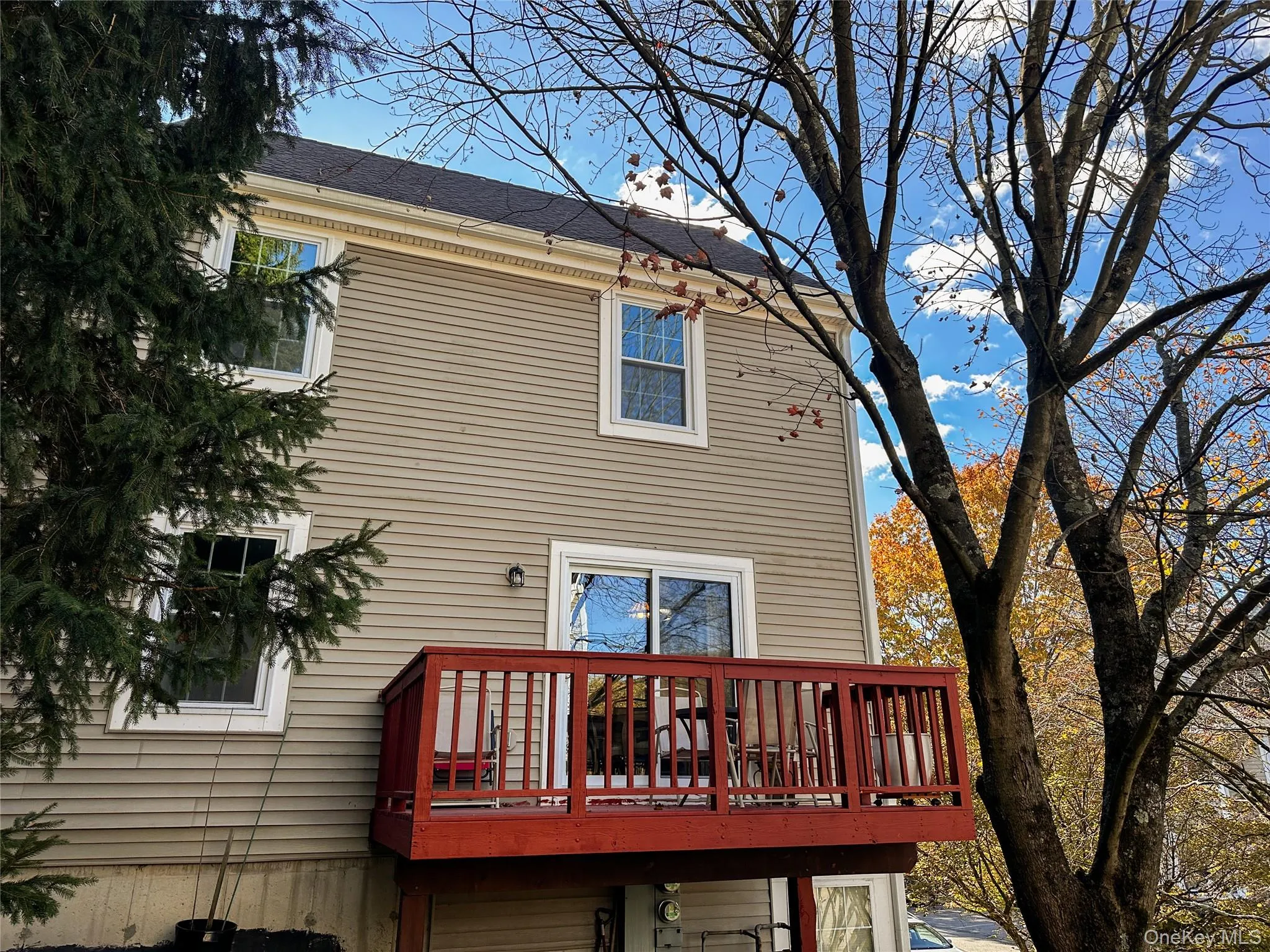 Rear view of house featuring a deck and a shingled roof Rear view of house featuring a deck and a shingled roof
