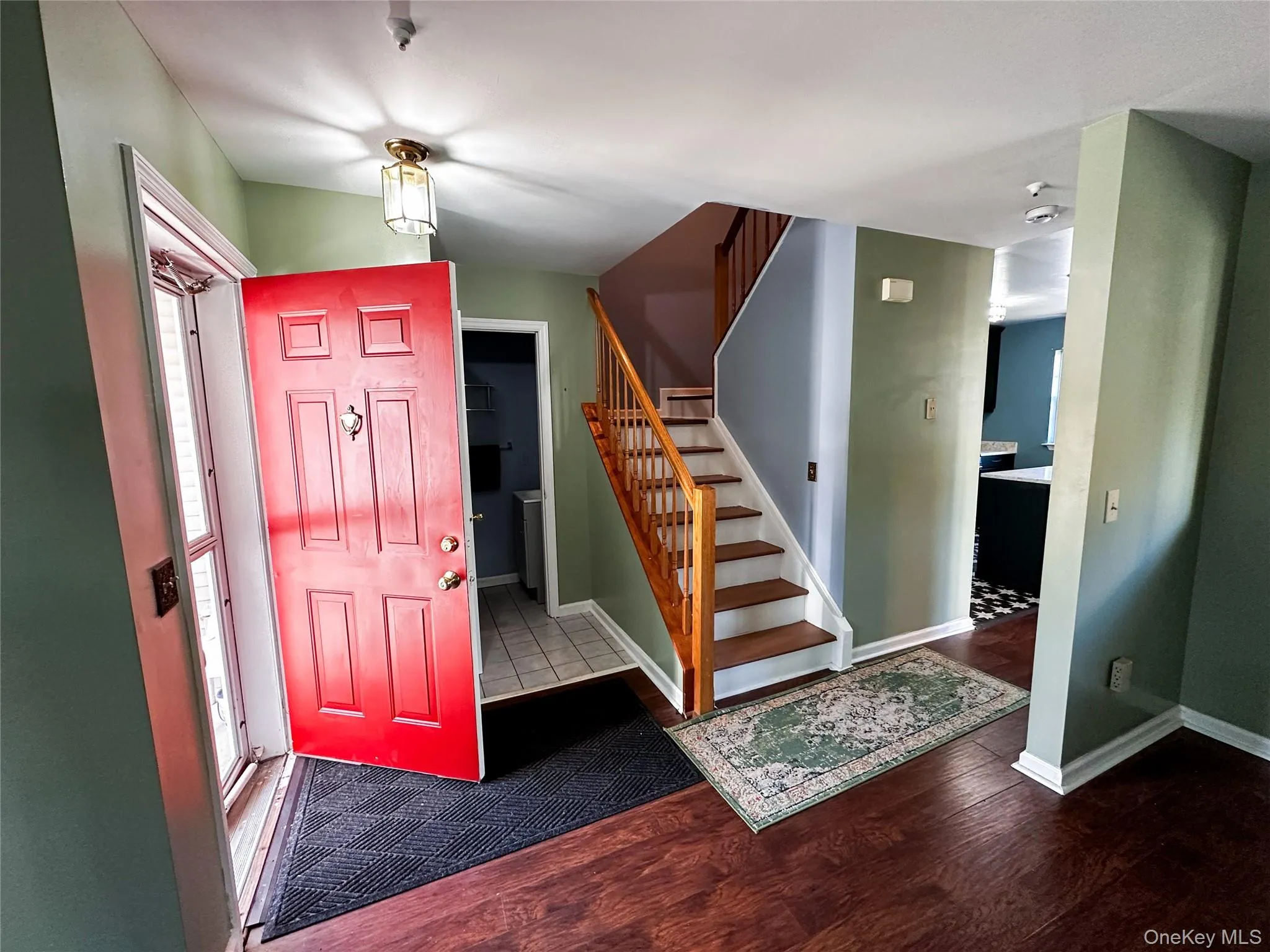 Entryway featuring stairs and dark wood-style floors Entryway featuring stairs and dark wood-style floors