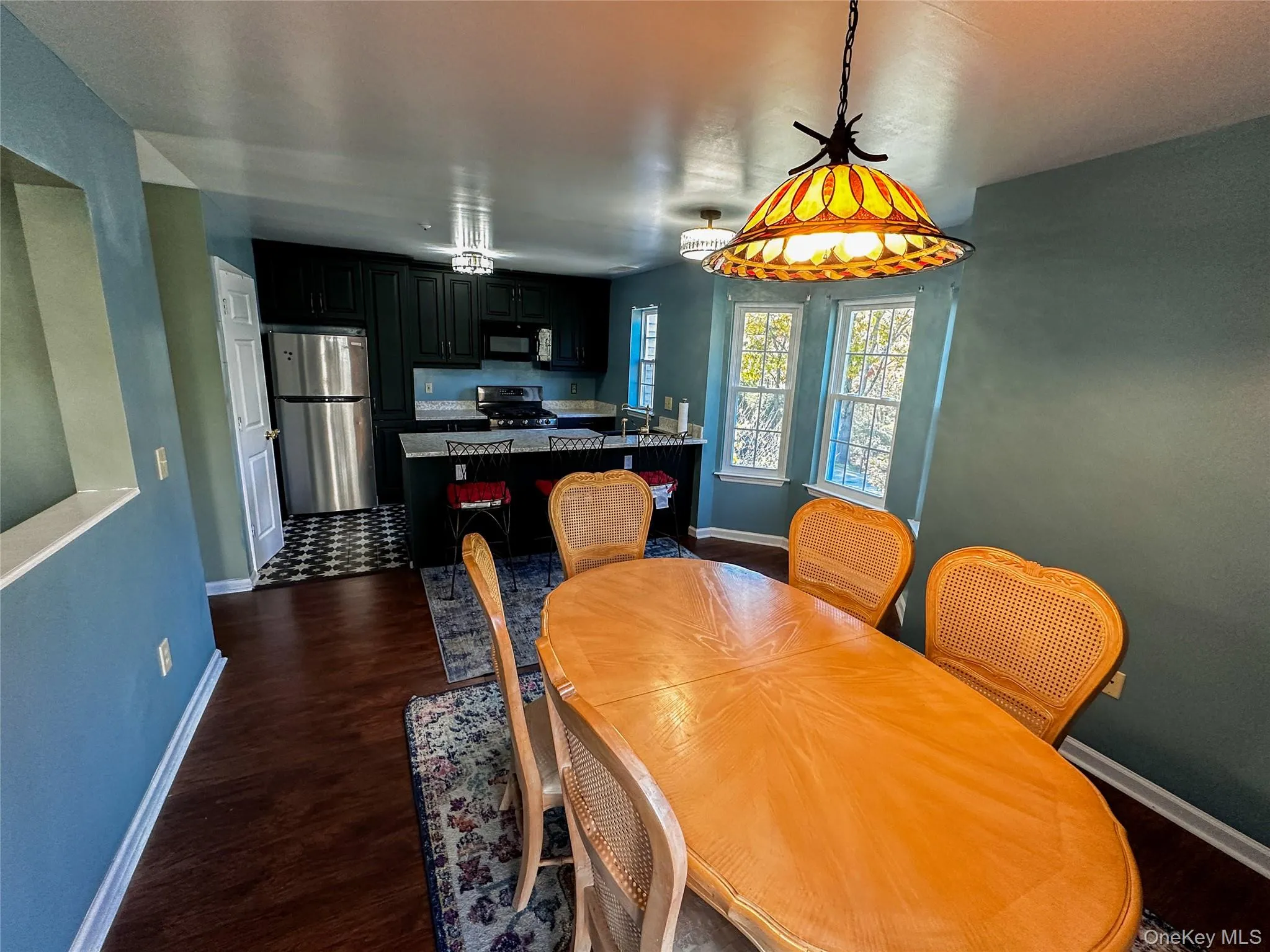 Dining area with baseboards and dark wood-style floors Dining area with baseboards and dark wood-style floors