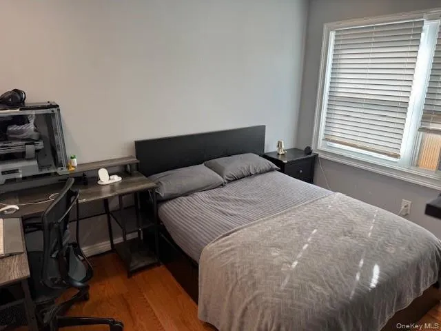 Bedroom with dark wood-style floors and an office area Bedroom with dark wood-style floors and an office area