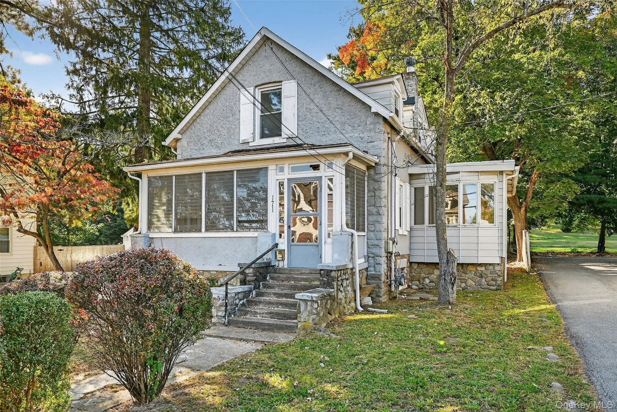 View of front facade with a chimney, a sunroom, a front yard, and entry steps View of front facade with a chimney, a sunroom, a front yard, and entry steps
