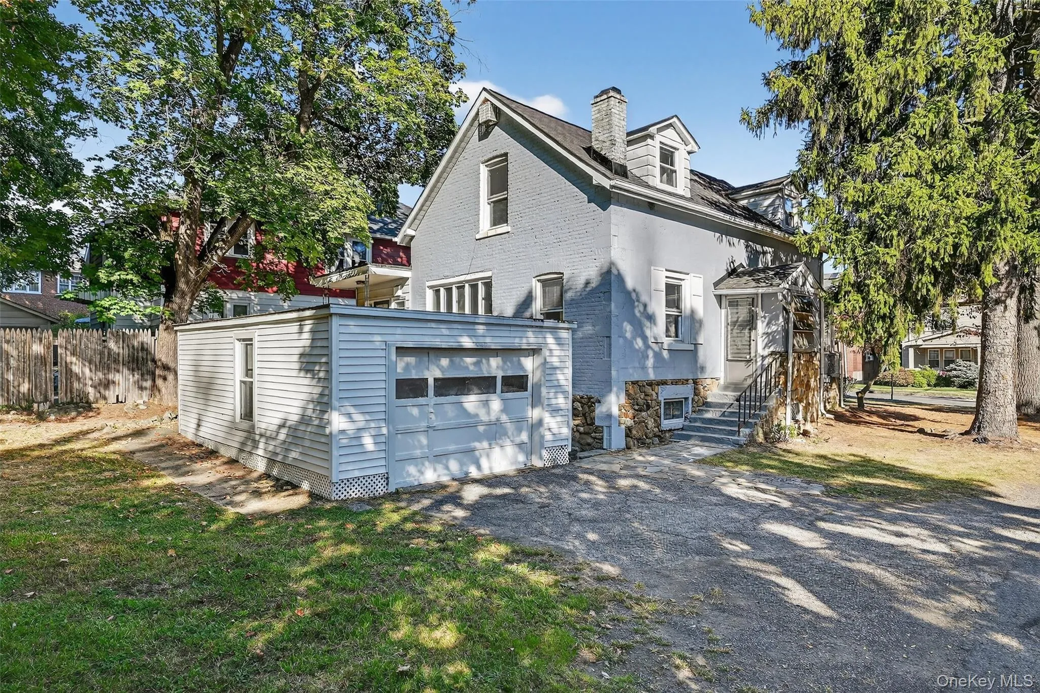 View of property exterior with driveway, a chimney, brick siding, an outdoor structure, and an attached garage View of property exterior with driveway, a chimney, brick siding, an outdoor structure, and an attached garage