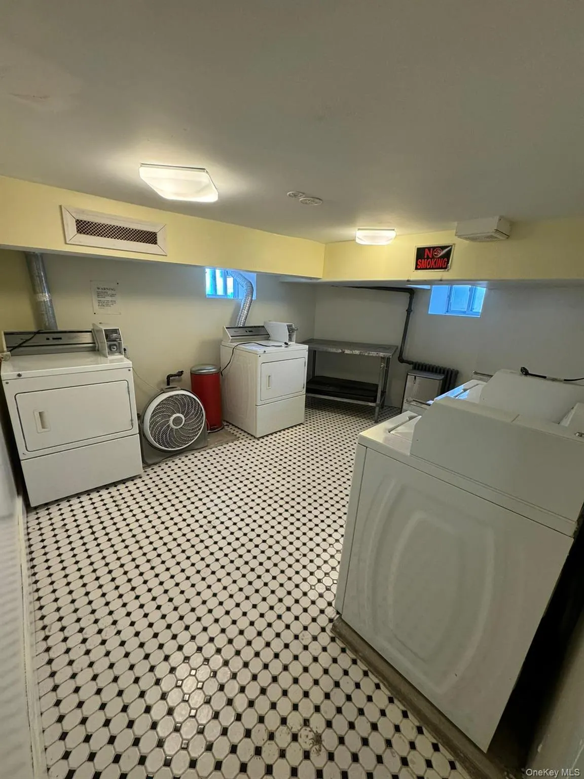 Communal laundry room with washer and dryer and light floors Communal laundry room with washer and dryer and light floors