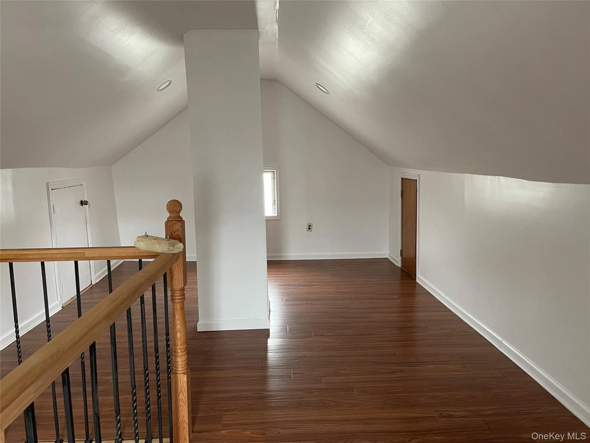 Bonus room with dark wood finished floors and lofted ceiling Bonus room with dark wood finished floors and lofted ceiling