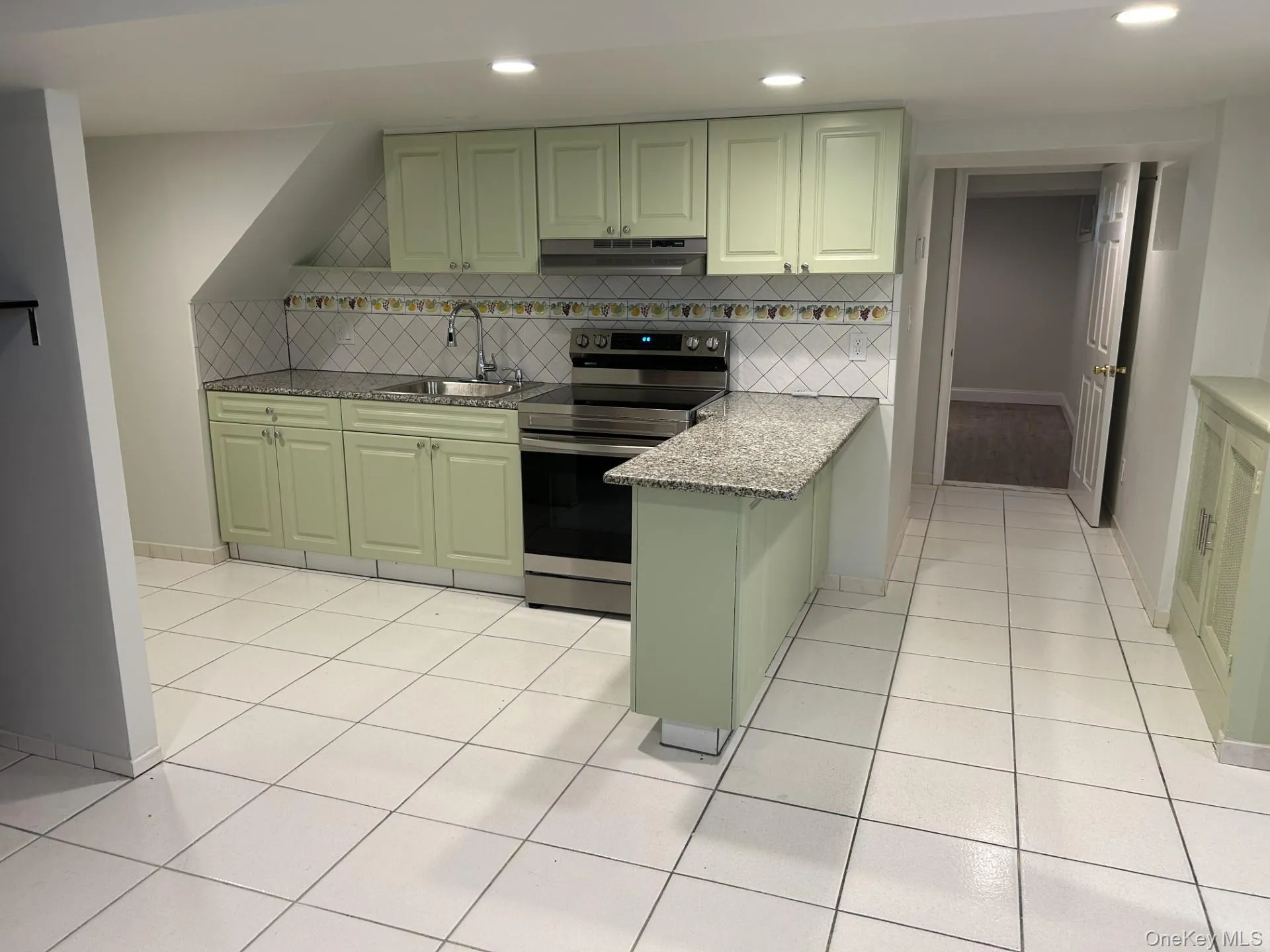 Kitchen featuring green cabinetry, stainless steel range with electric stovetop, light stone counters, recessed lighting, and under cabinet range hood Kitchen featuring green cabinetry, stainless steel range with electric stovetop, light stone counters, recessed lighting, and under cabinet range hood