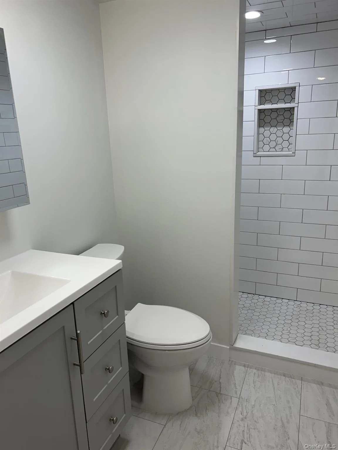 Bathroom with vanity, a stall shower, and light marble finish floors Bathroom with vanity, a stall shower, and light marble finish floors